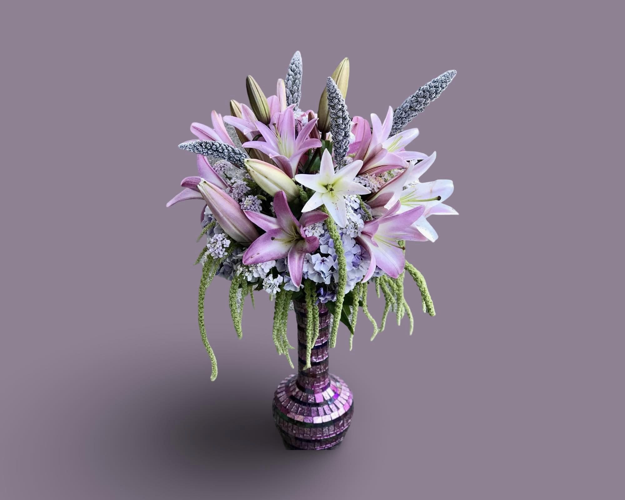 Lily Lover Lily Lover - An artistic and soft arrangement is a pleaser and interesting as it is impressive. pink, and White lily is an architectural design give this arrangement its unique appeal with a wonderful smell Beter than perfume. exact Vase is not available it will be made in clear Vase APPROXIMATE DIMENSIONS 12"W X 18"H Standard 14"W X 22"H Deluxe 16"W X 25"H Premium