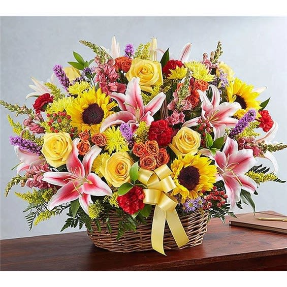 Heartfelt Farewell Bright Heartfelt Farewell Bright - A gorgeous display of colorful blooms arranged in a wicker basket. Includes sunflowers, vibrant stargazer lilies, fresh roses, and more. 28"H x 24"W