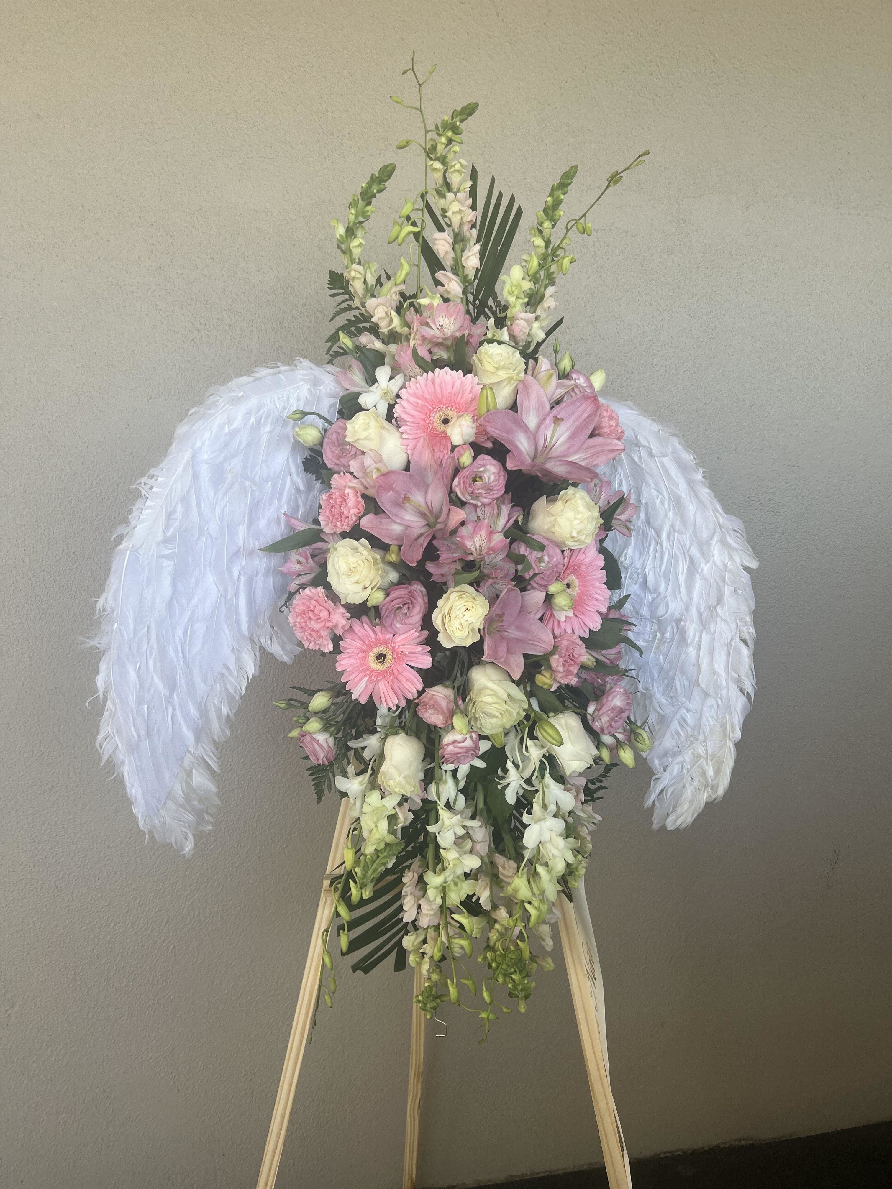 Angel Wings Standing spray  - PLEASE NOTE MUST PREORDER. Beautiful standing spray with angel wings with a cluster of flowers in the center. 