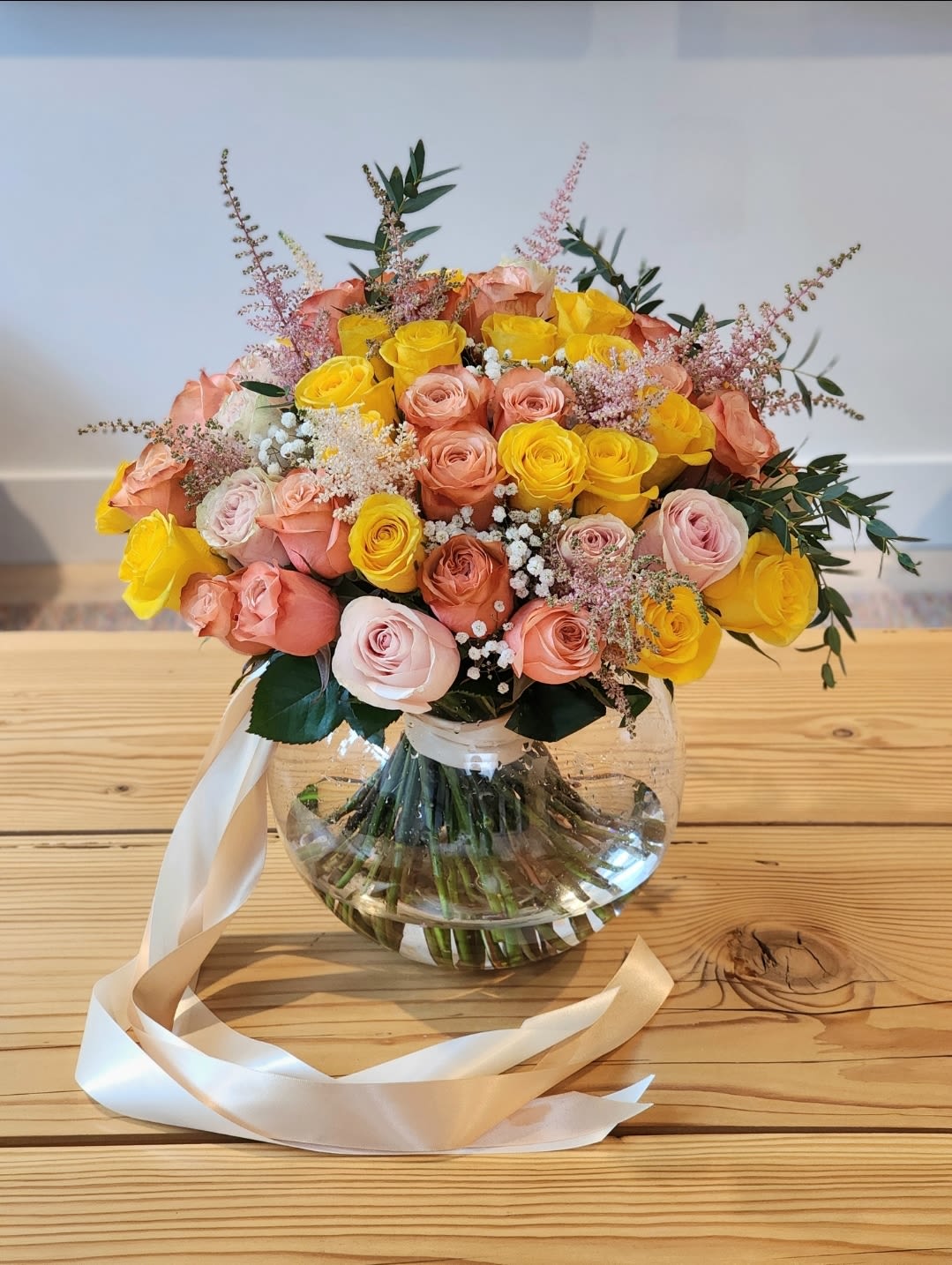 Autumn Treats  - A vase filled with peach and yellow roses radiates elegance and warmth.The lush green foliage adds a natural touch, enhancing the overall charm and making it perfect for brightening any space.