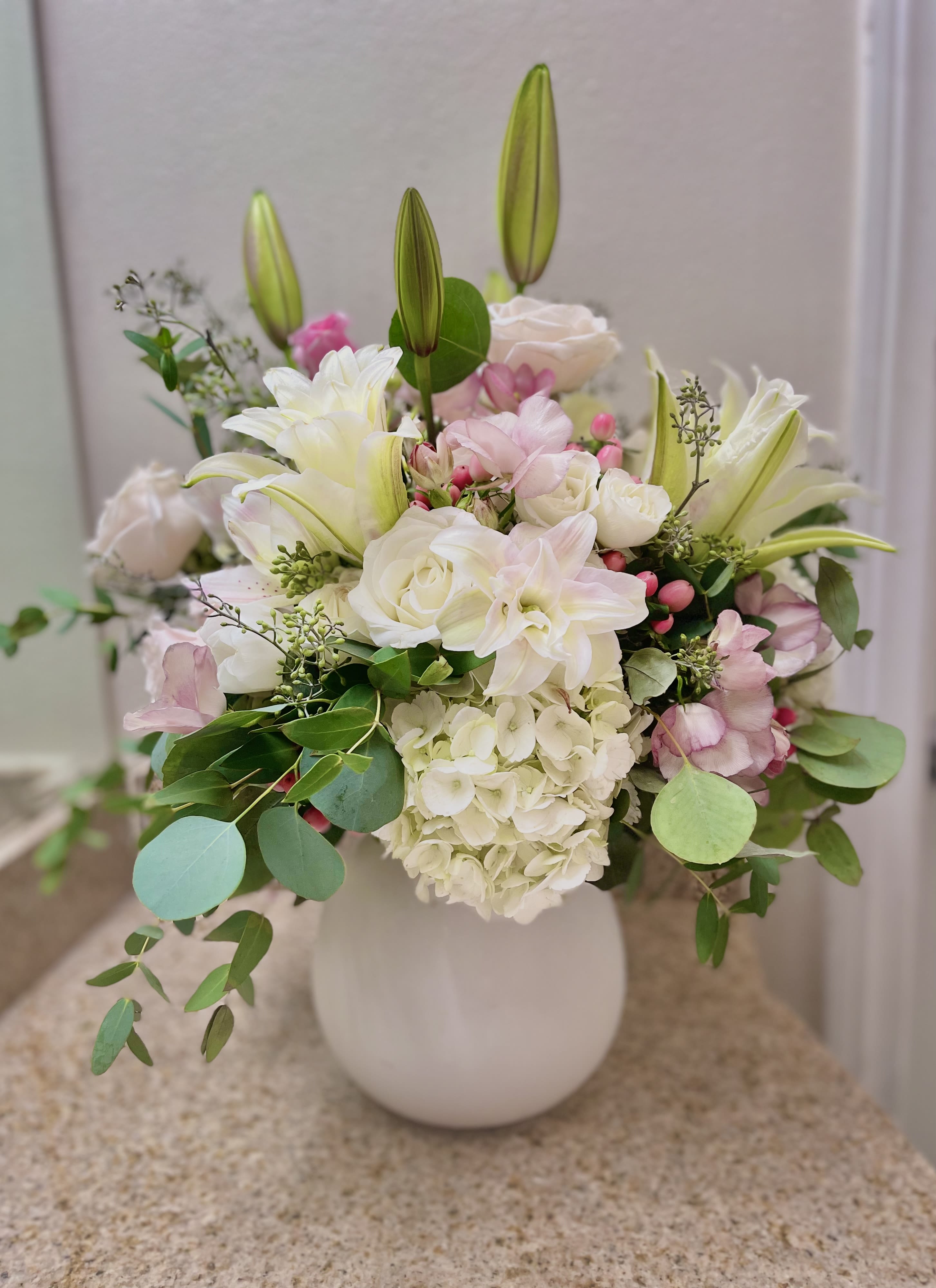 Sweet Serenity  -  A gorgeous mix of soft pastel and white flowers in a hand made white ceramic vase. Double sided, big and full arrangement