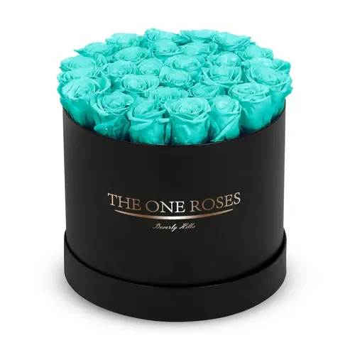 Round Flat | Classic Black Box teal blue Round Flat | Classic Black Box teal blue - The "runway round collection" consists of unique, real preserved roses in classic round handcrafted luxury soft touch box with a top. About 25-30 stems of the one long lasting (med size) preserved roses.  Durability: approx. 1-3 years.  Our roses, which are carefully sourced from the highest quality gardens in Ecuador, are made to represent the eternal yet ephemeral nature of Love itself. Our Roses are specially customized with essential oils to increase the fragrance.  Product Care: DO NOT Water the roses! AVOID direct exposure to sunlight. Keep the arrangement in a room-temperature environment. If dust collects after a few months, remove it lightly using a duster. DO NOT place anything onto the roses as they can crush and damage the roses. DO NOT remove the roses from the box; they are secure and happy there. DO NOT allow roses to have direct contact with light colored fabric or surfaces, as staining may occur. The lid is meant to stay on the side or bottom of the box. Be mindful when carrying the arrangement: it's a very delicate product!