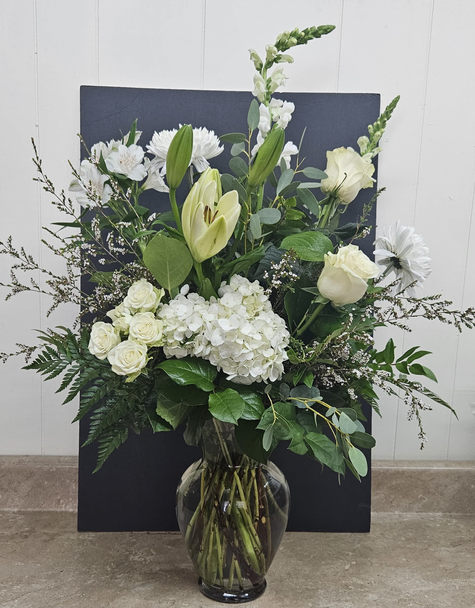 White Delight - A classic and elegant arrangement of white roses, white hydrangea, white snaps and white lisianthus.