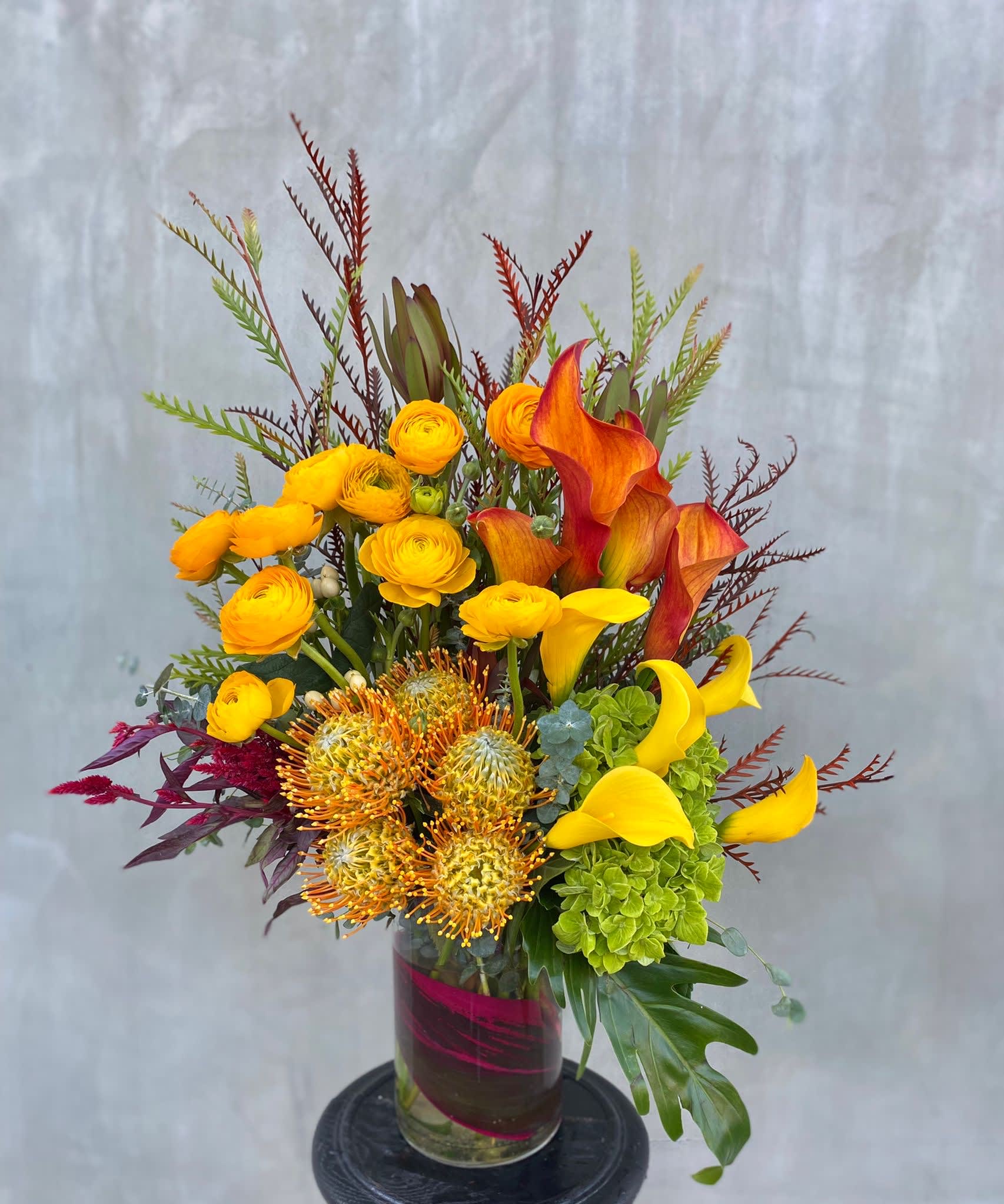 Pretty in Orange - Ranunculus, calla lilies, proteas, hydrangeas, all hand-arranged in a vase. 