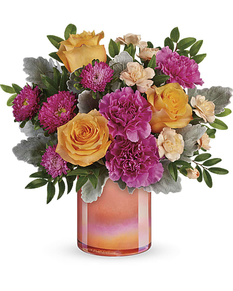 A Perfect Spring Peach Bouquet - Like a spectacular spring sunset, this radiant bouquet of oranges and pink blooms, presented in a peach glass vase with shimmering pearlized finish is sure to brighten anyone's day! This bouquet features peach roses, dark pink carnations, peach miniature carnations, hot pink matsumoto asters, dusty miller, and huckleberry.
