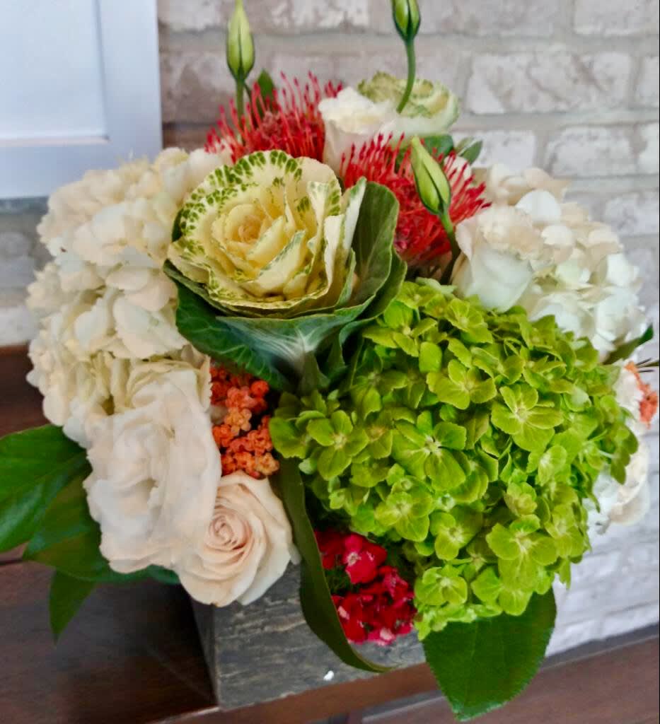 Classic Rust Classic Rust - Hydrangeas, white roses, flower kale, and proteas arrange in a wood like vase.