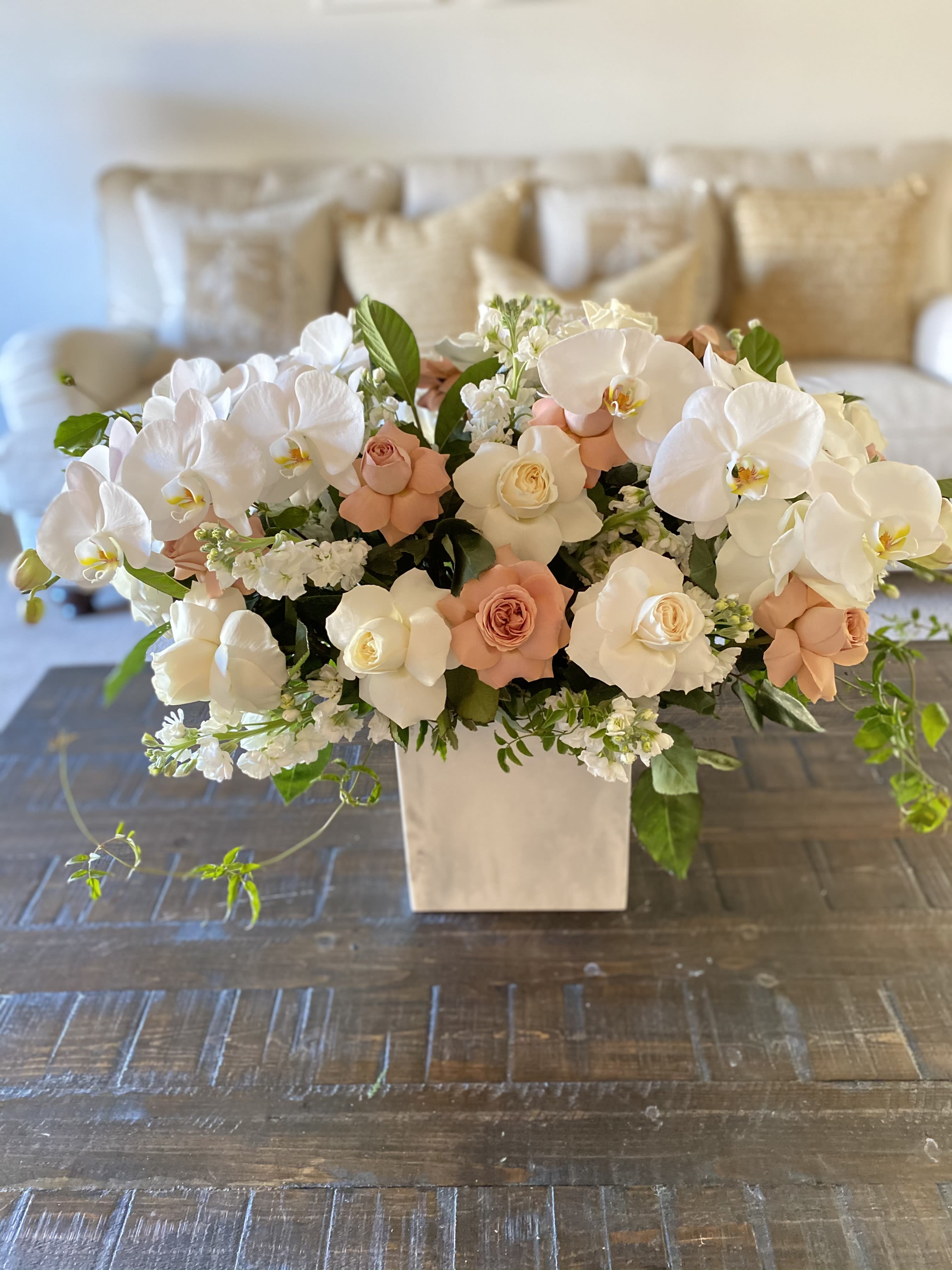 Blushing Clouds Blushing Clouds - This floral design is elegant and delicate. White and greens are paired together through the use of white phalaenopsis orchids, with a small touch of blush cappuccino roses.