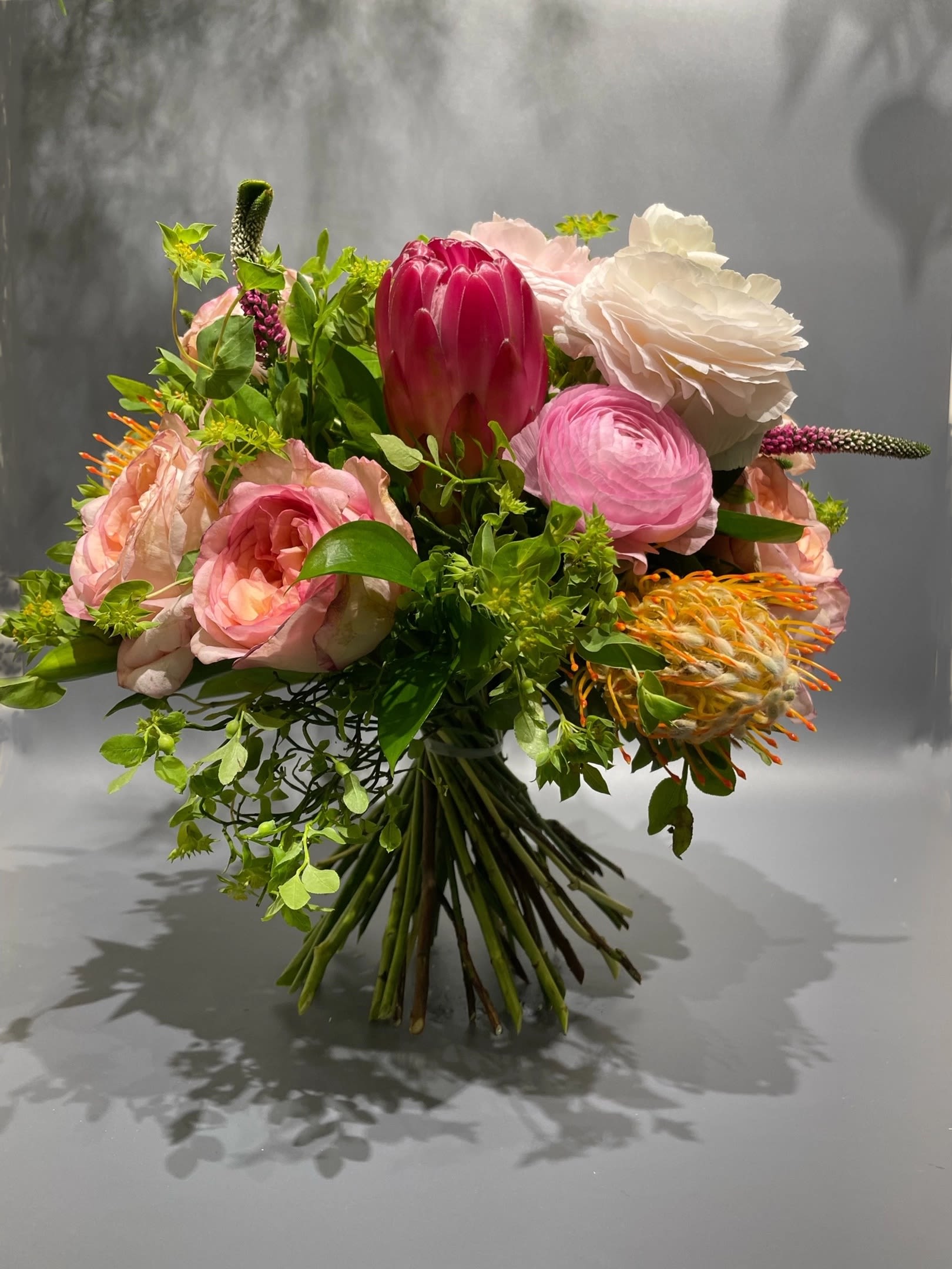 Autumn's Embrace - This autumn bouquet in a pumpkin vase combines warm-toned roses, chrysanthemums, and fresh greenery. The natural pumpkin adds a cozy and festive touch, making it a perfect centerpiece or gift for any fall celebration.