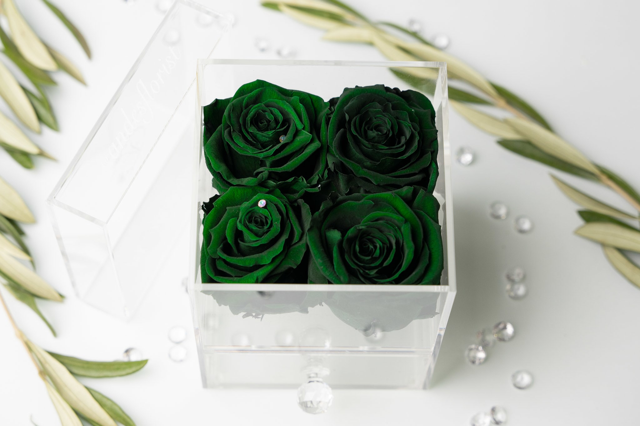 Acrylic Jewelry Case of 4 One Year Roses - Forest Green - These are REAL rose that can last for up to a year, or longer! Placed beautifully in an acrylic jewelry case with a multipurpose drawer.  About: Our One Year Roses are imported directly from Ecuador where they are treated with a proprietary solution and color pigmentation process that transforms them into long-lasting roses that maintain their freshness and biological structure. The roses are treated using a non-toxic and non-allergenic wax formula that is similar to silica. The outcome is that our roses continue to look and feel like real roses - because they are real - with the difference being that they will maintain their integrity and color for up to a year.  Maintenance: The only maintenance they require is a light dusting from time to time. Do NOT water the roses. Do NOT remove the roses from their container. Do NOT place anything onto the roses as they can crush and damage them. Avoid direct exposure to sunlight. Keep the arrangement in a room temperature environment. 