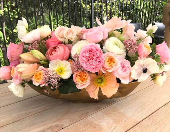 The Ultimate Garden - This beautiful arrangement is in a golden vase with a wide variety of garden roses, spray roses, anemones, poppies, ranunculus, and rice flower. 