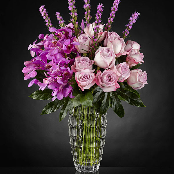 The FTD Modern Royalty Luxury Bouquet, vase will vary in style The FTD Modern Royalty Luxury Bouquet, vase will vary in style - Opulent in every way to bring a certain majesty to any place it may be set this stunning flower bouquet exudes true artistry through its use of color and texture. Notice the lavender swirl of roses offset by the fanciful layers of petals brought on by stems of lavender alstromeria with a crown of purple liatris extending from the top. Arranged to perfection in a clear faceted glass vase to add even further texture and interest as it reflects light from its surroundings this gorgeous luxury bouquet is ready to turn an ordinary day into something quite extraordinary indeed. IMPRESSIVE bouquet includes 26 stems. Approx. 26"H x 17"W. STUNNING bouquet includes 37 stems. Approx. 27"H x 18"W.