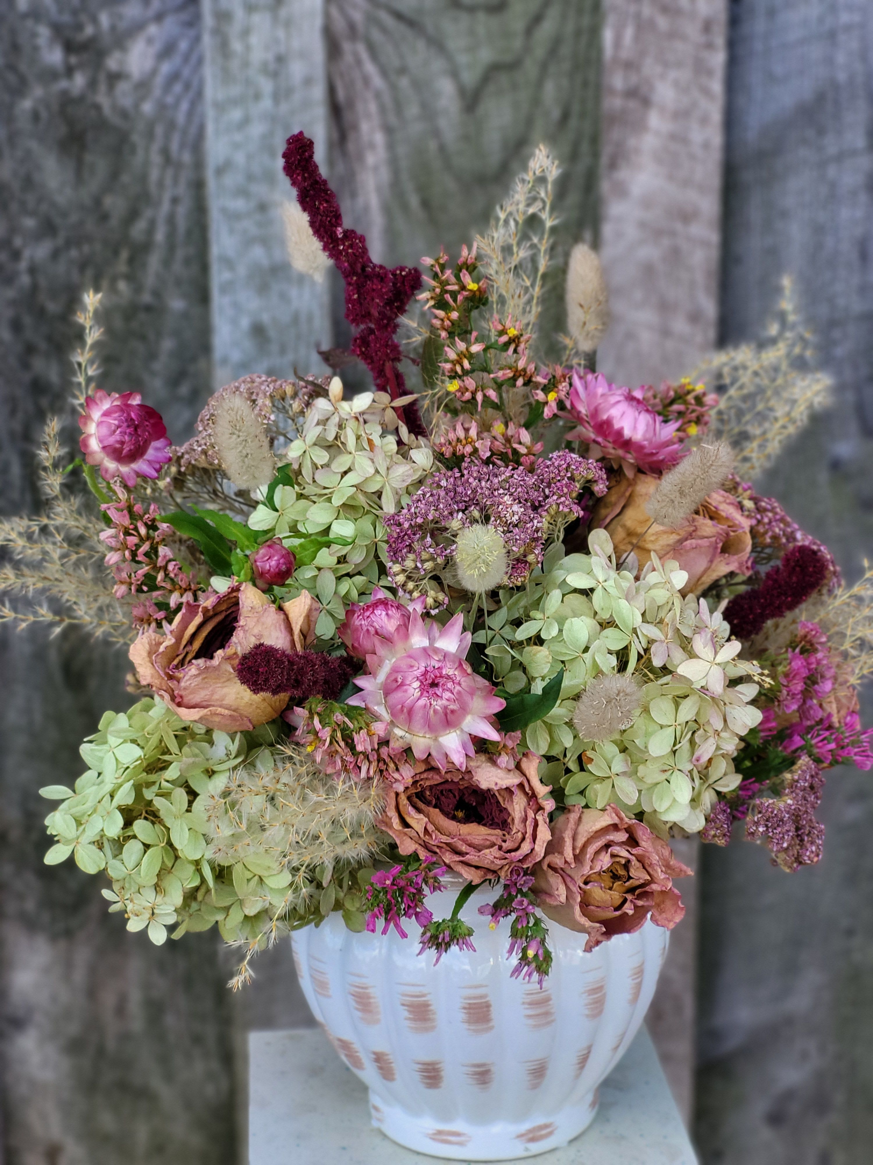 Dried Bouquet - Everlasting Delight Dried Bouquet - Everlasting Delight - A lovely ceramic cream colored vessel is filled everlasting dried blooms such as hydrangea, roses, strawflower, celosia and more. This items is made using our own dried blooms- and will last for years to come. Please keep out of direct sunlight to avoid fading, but this will be a gift meant to last!