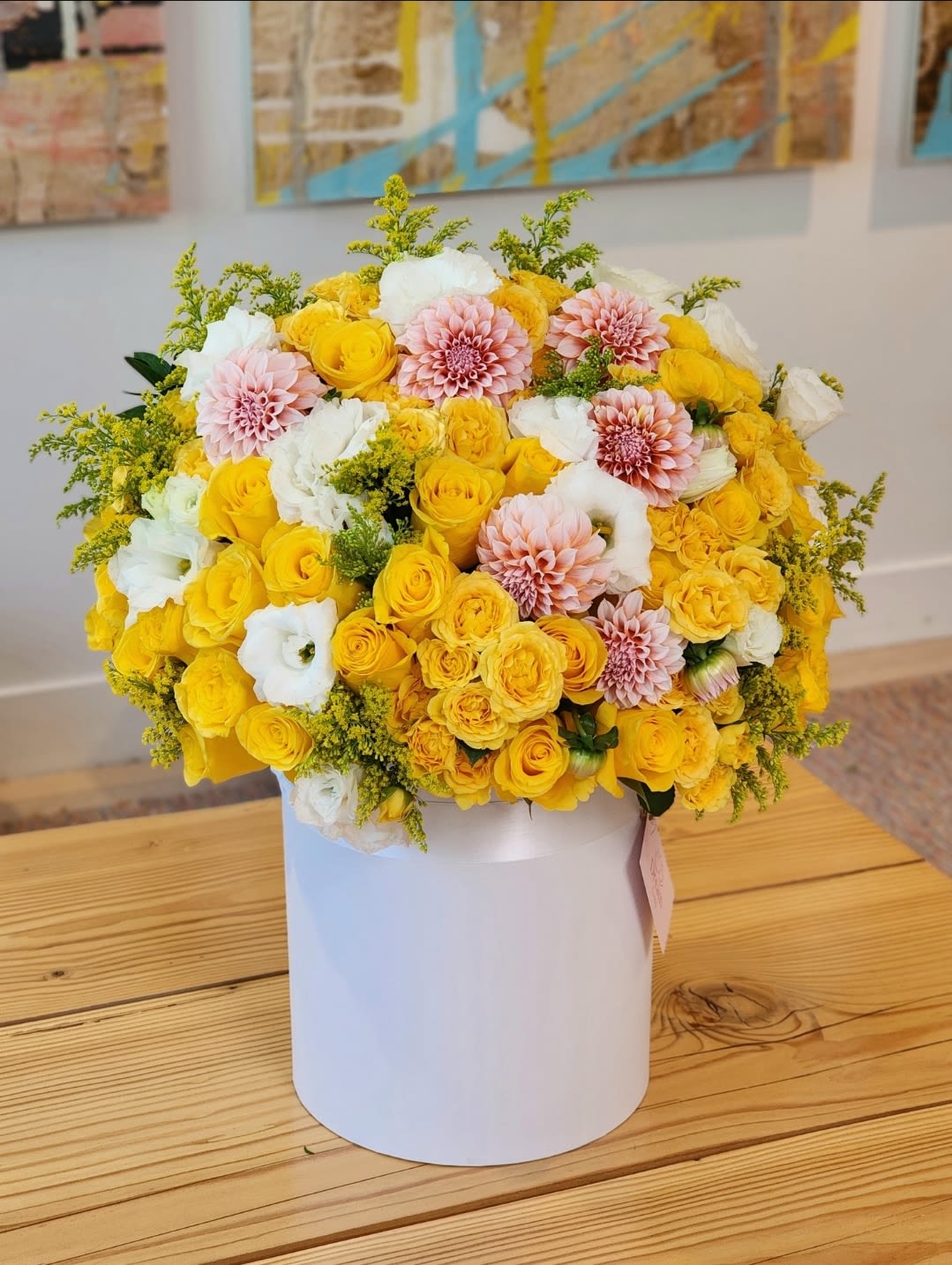 Sunlit Elegance - This deluxe floral arrangement features a vibrant mix of yellow and white combinations. A lively and cheerful display.  It's a stunning arrangement perfect for any joyous occasion.