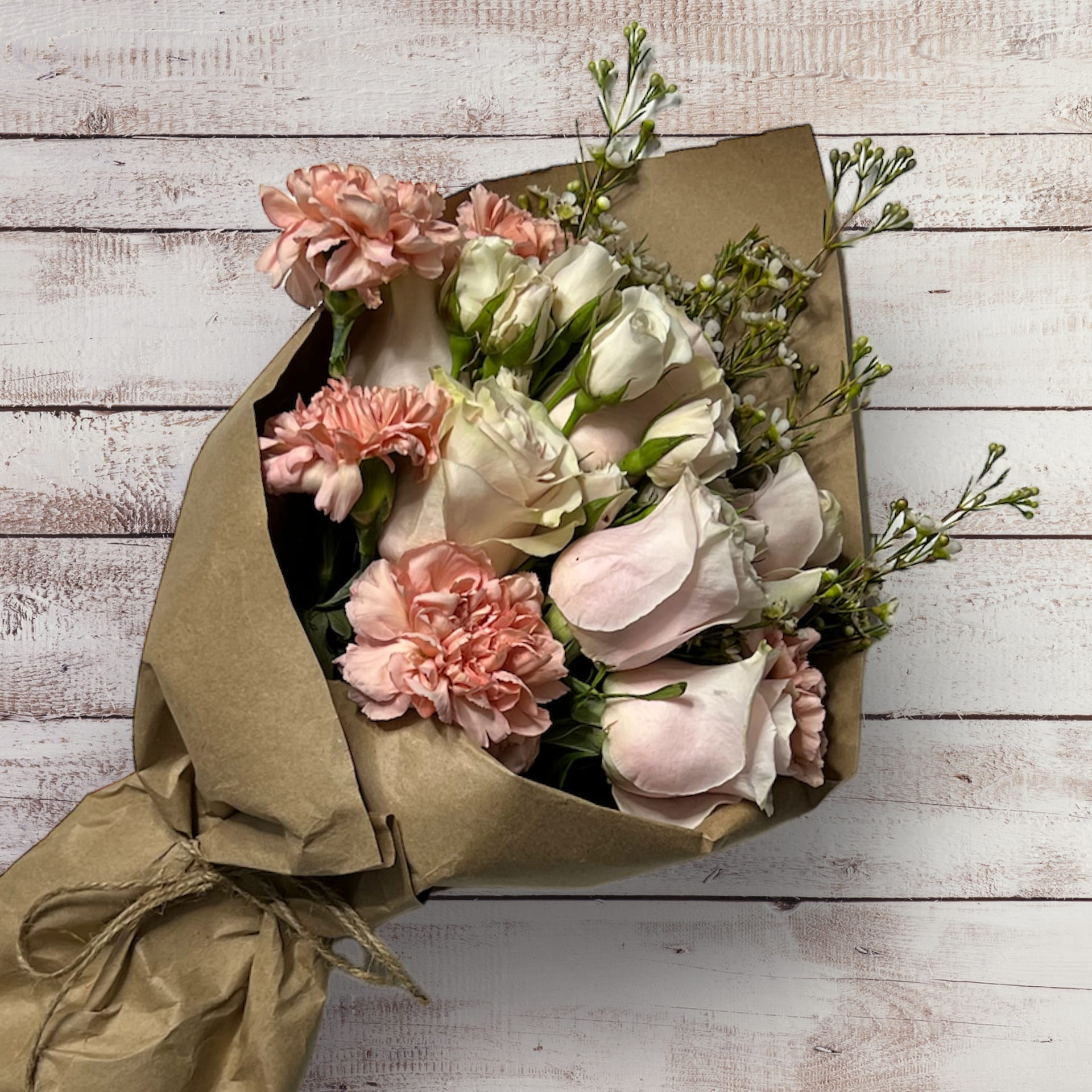 Blushing Romance - A gorgeous combo of blush roses, spray roses and carnations, surrounded by airy wax flowers. Ethereal and romantic.
