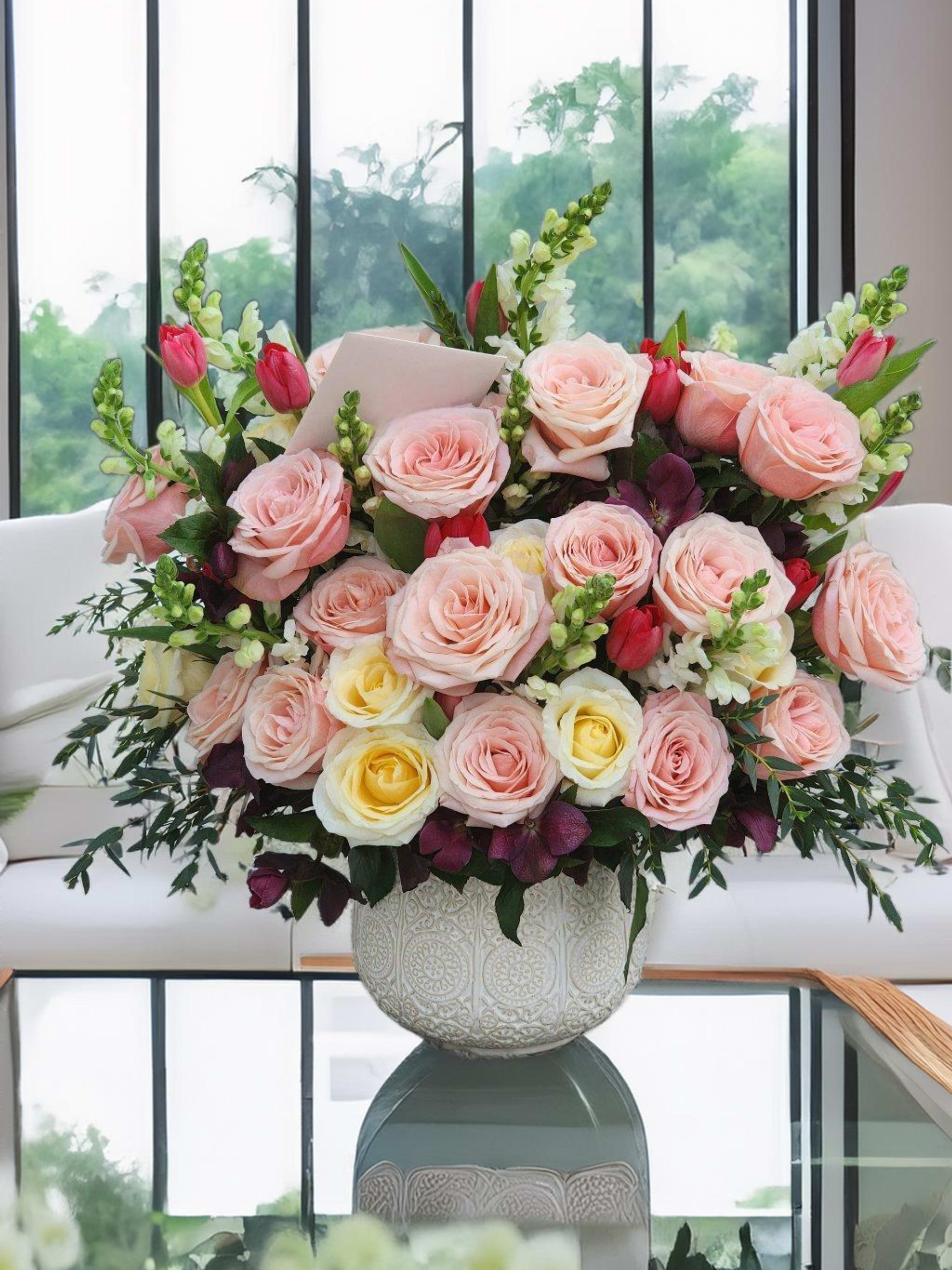 Girlish  - This stunning floral arrangement in a ceramic vase features of pink roses, pink tulips, while lush greenery completes the luxurious design. Perfect for upscale events and special occasions. 
