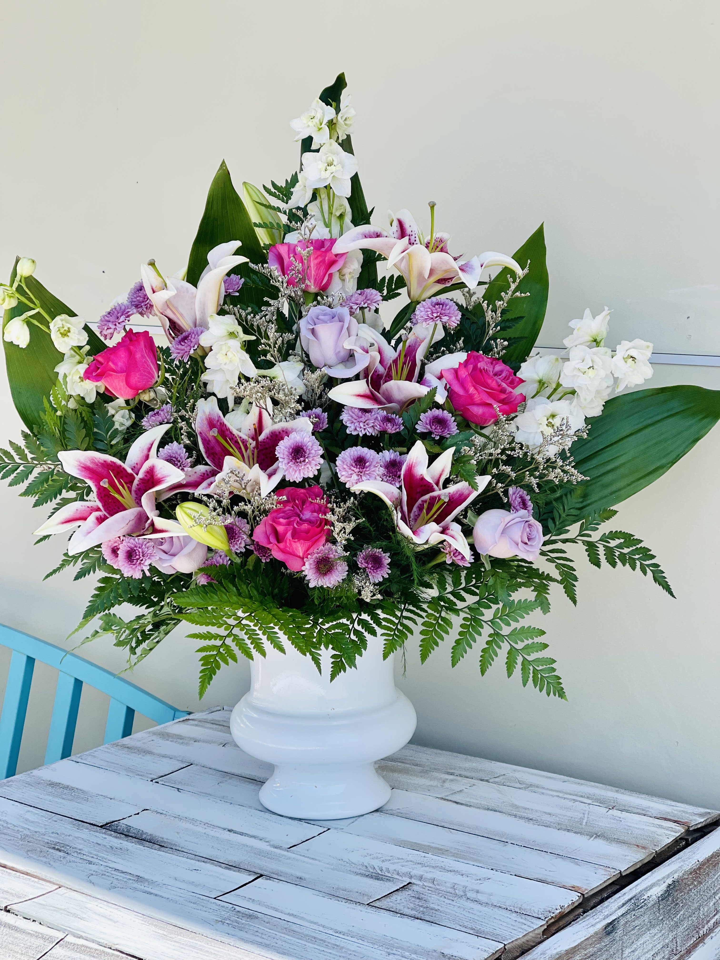 Lilies in Loving Memory - This Beautiful sympathy arrangement includes star gazer lilies, purple and pink roses, white delphinium in memory of that special loved one.