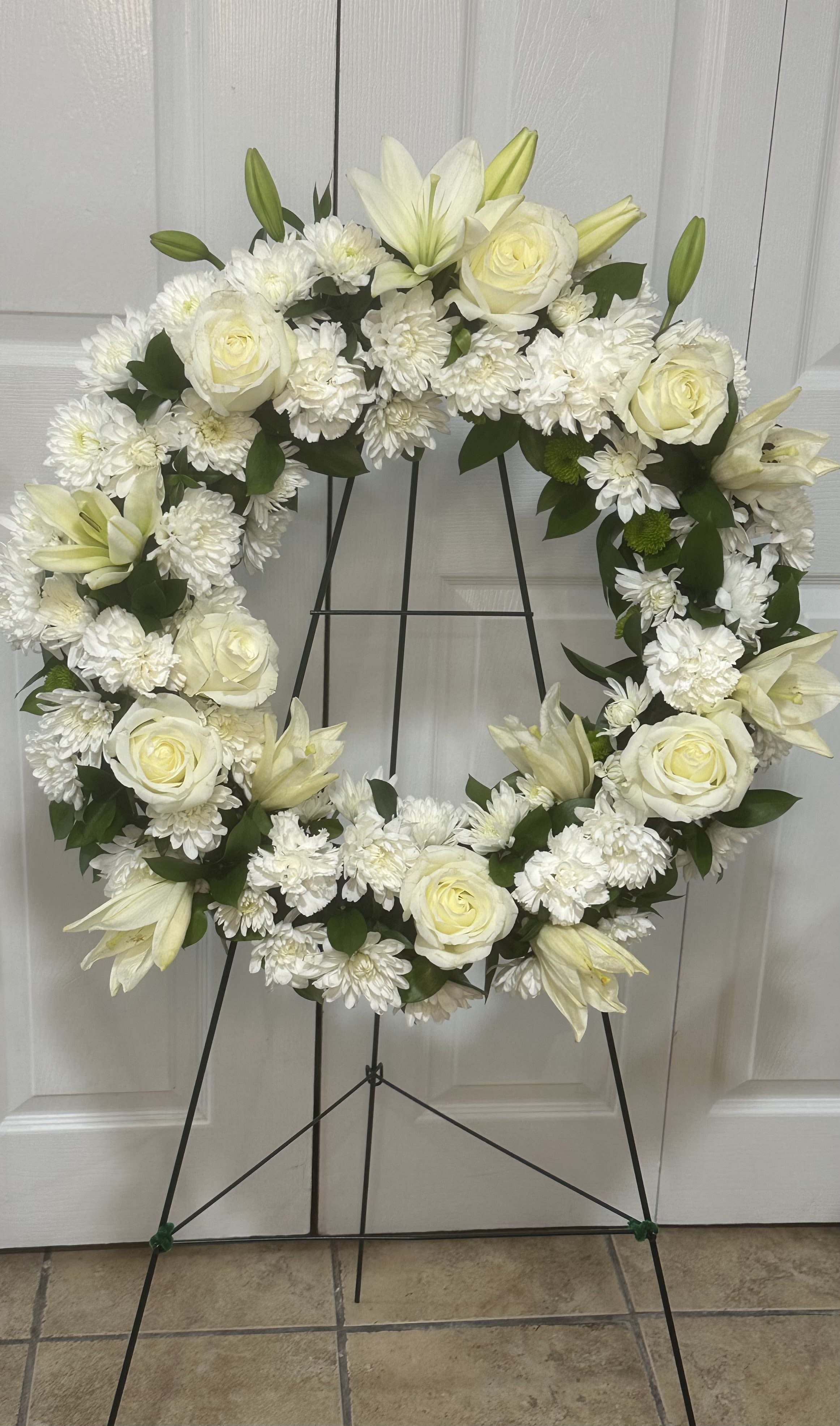 White Elegance Wreath by Petals 2 Go - This elegant classic wreath with bright white blossoms will create a serene display at any funeral or wake and will express sincere sympathy delivered on an easel.