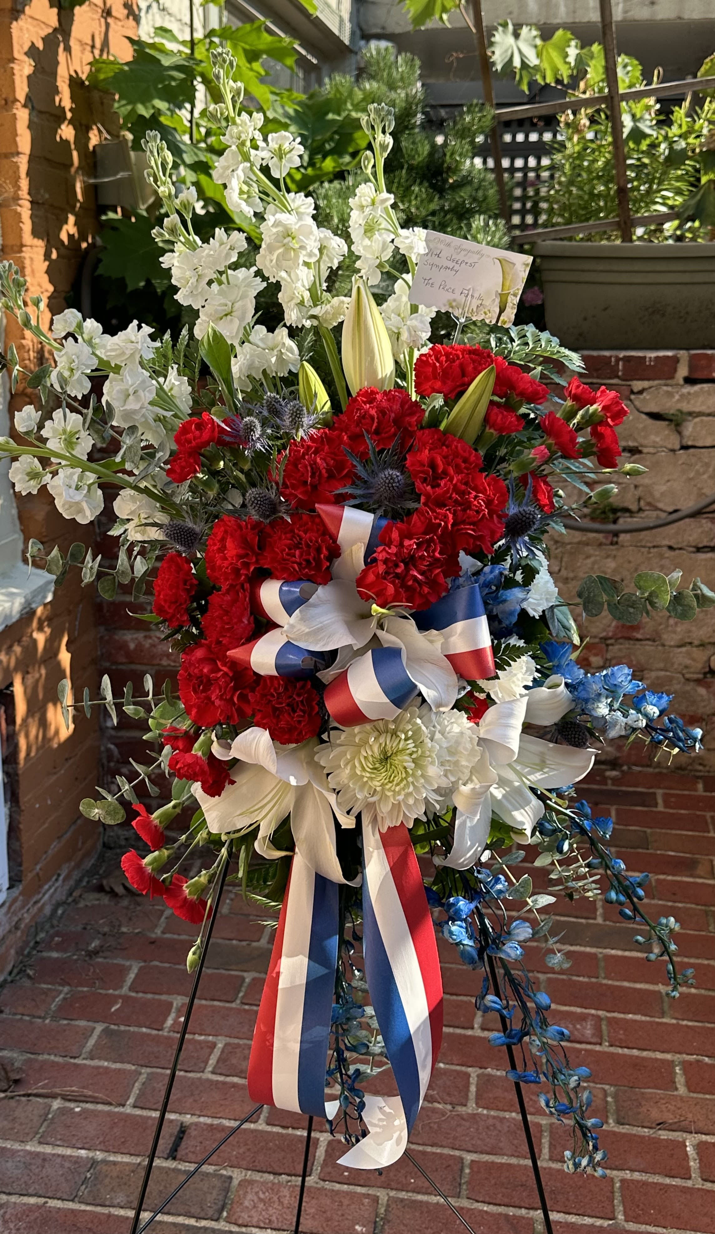 Patriotic Remembrance by Petals 2 Go Patriotic Remembrance by Petals 2 Go - This beautiful spray of red, white and blue flowers during a time of loss conveys a message of reassurance and hope.