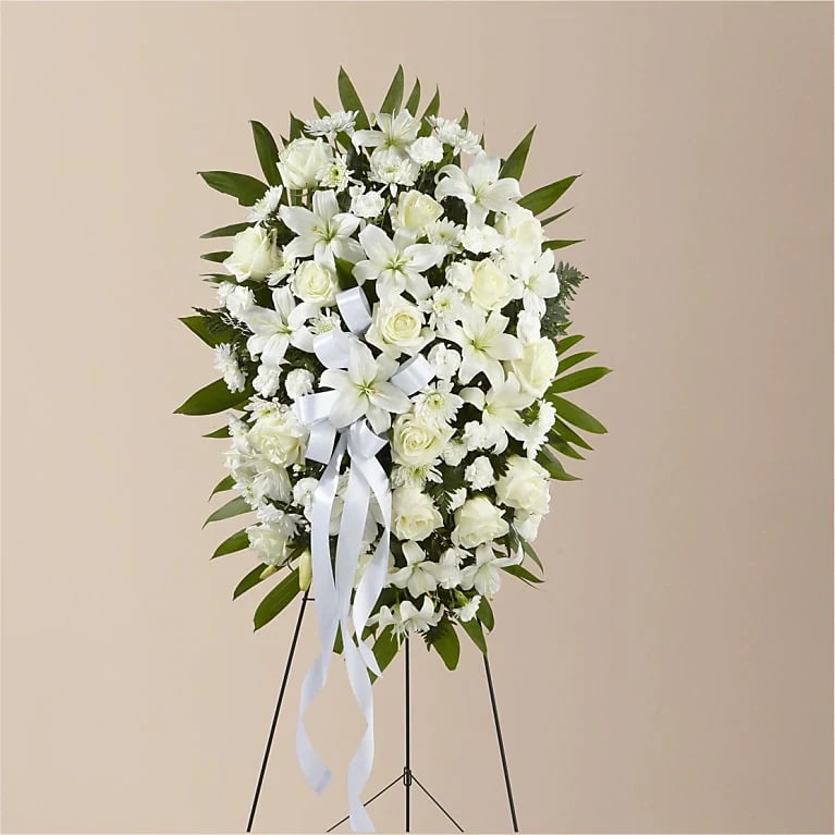 Exquisite Tribute Standing Spray - White Ribbon - For Service Exquisite Tribute Standing Spray - White Ribbon - For Service - The Exquisite Tribute Standing Spray is an elegant display of sweet serenity. White roses, Asiatic lilies, chrysanthemums and mini carnations are artfully arranged amongst emerald palm fronds and lush greens. Accented by white satin ribbon and standing on a wire easel, this standing spray is an outstanding way to honor the life of your loved one. Optional Banner included upon request. Include your banner message in the Florist Instructions during checkout, or give us a call at (562)692-0438.