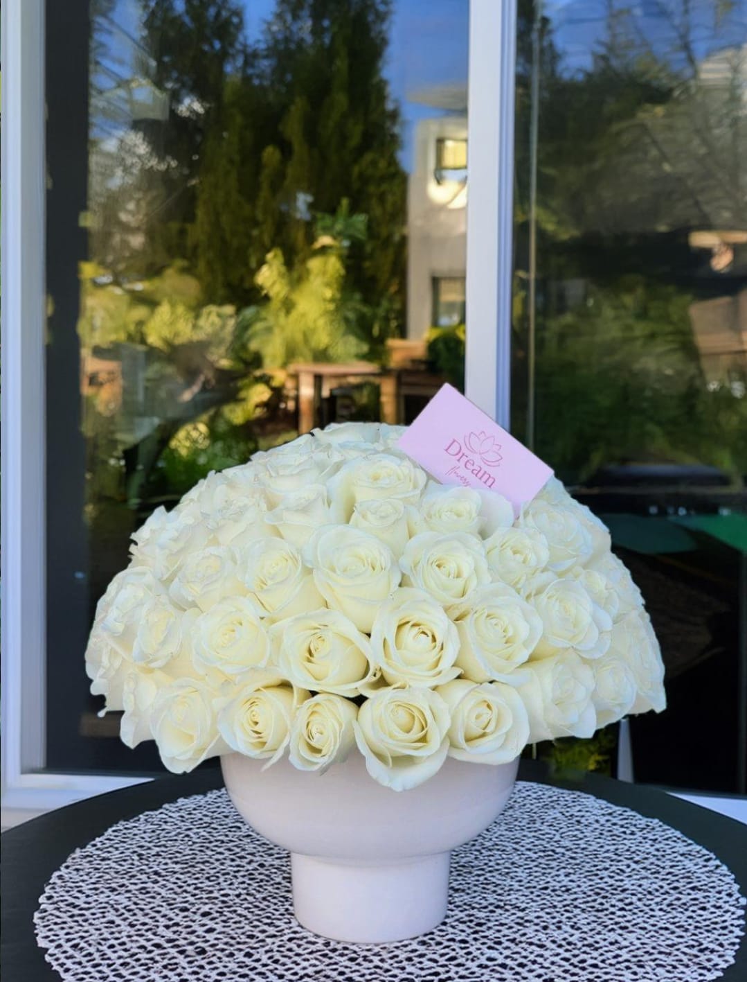 Whispering Memories - Pure elegance captured in a timeless arrangement: pristine white roses delicately cradled in a white vase. Perfect for any occasion, embodying grace, purity, and understated beauty.         