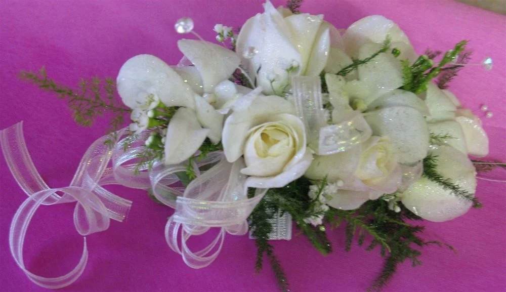 Corsage 4 - White rose and white dendrobium orchid Wrist corsage with 5 - 7 beautiful blooms, crystal sprays, greens, wax flowers, French iridescent ribbon. Please call the store. Discount will be given to students.  