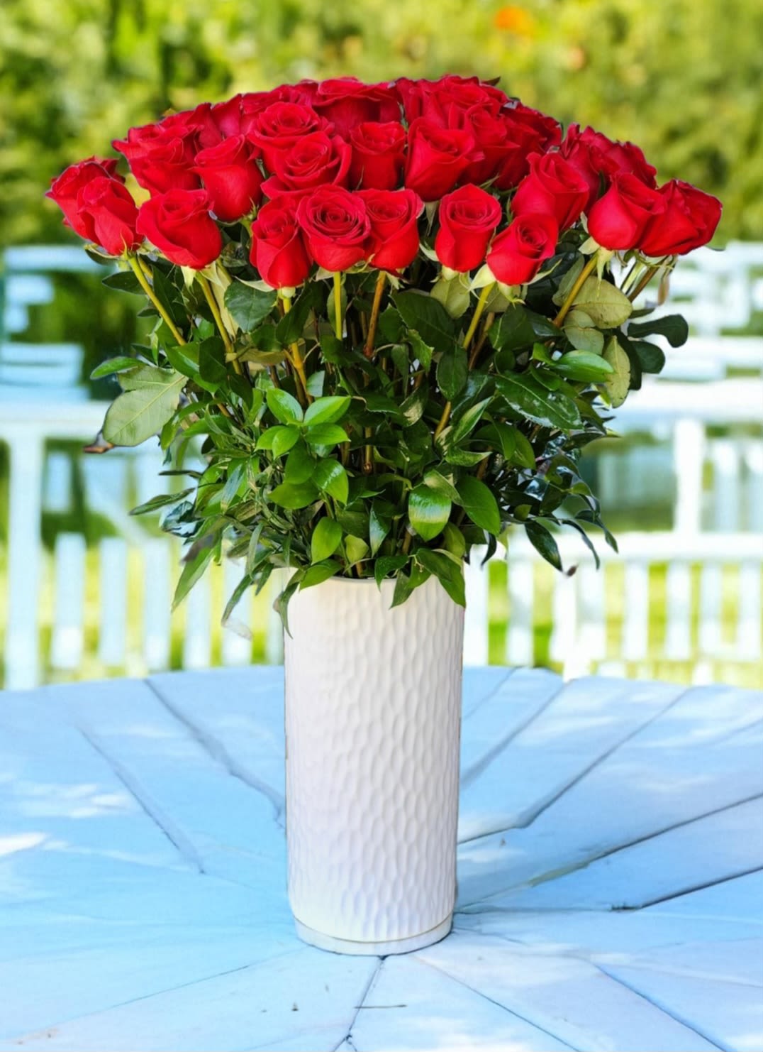 Classic Red Roses - Classic arrangement of red roses in white tall vases is perfect for anniversaries, proposals, birthdays, and weddings. The striking red and white contrast creates a stunning, elegant display, making it ideal for any special occasion. 