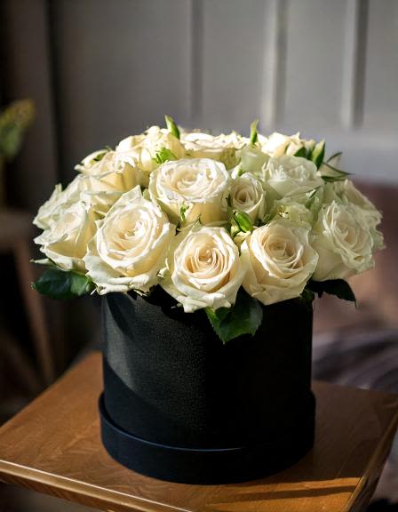 White Dreams - Make a statement with our stunning white roses in black hatbox. Ideal for birthdays, anniversaries, or just because, this arrangement is a symbol of pure elegance. Elevate any space with this beautiful floral display.