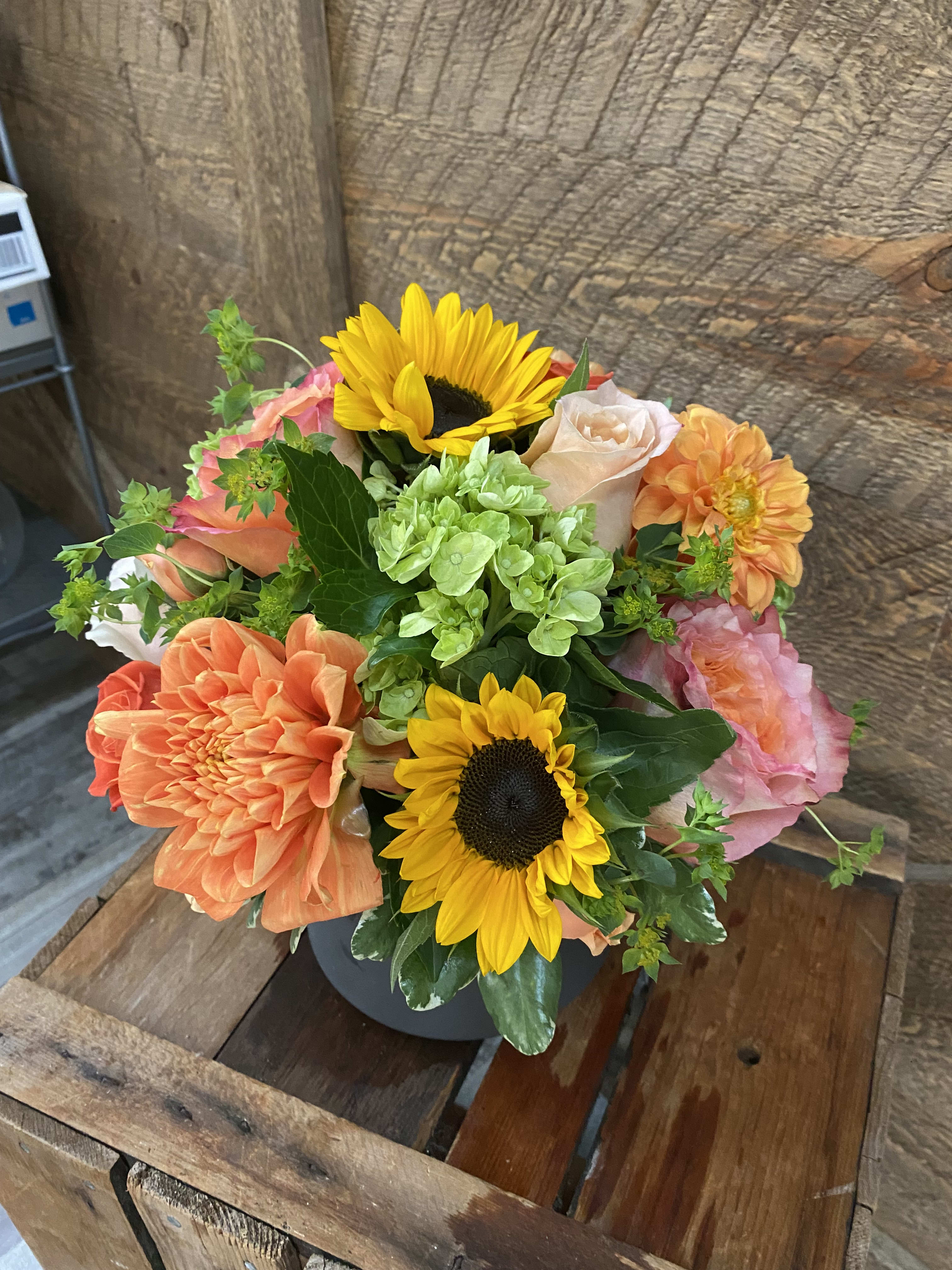 Sweet Sugar Maple Sweet Sugar Maple - A beautiful soft autumn arrangement. Gorgeous mix of roses, green hydrangea, sunflowers, and poms. Arranged perfectly in a container.