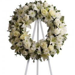 Classic White Wreath - Classic White Wreath is composed of a variety of seasonal white flowers. roses and lilies are an example of the statement flowers, while fresh greenery is used to accentuate the white. 