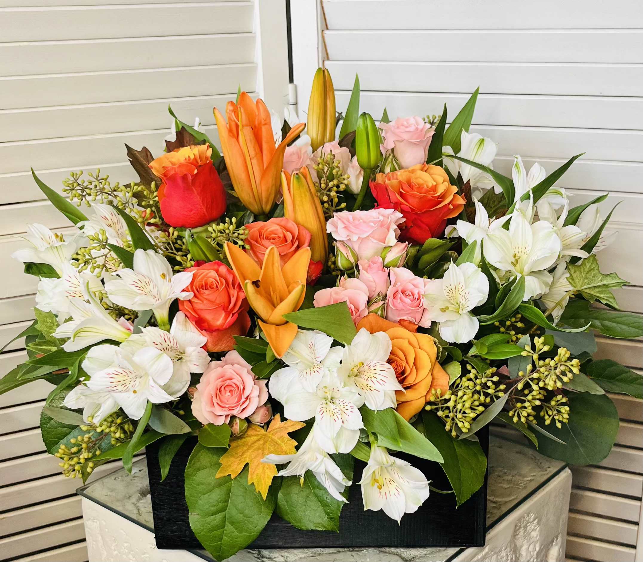 Fall Mix - This impressive fall arrangement features orange roses, lilies, light pink spray rose, and white alstroemeria deliver in a wooden box