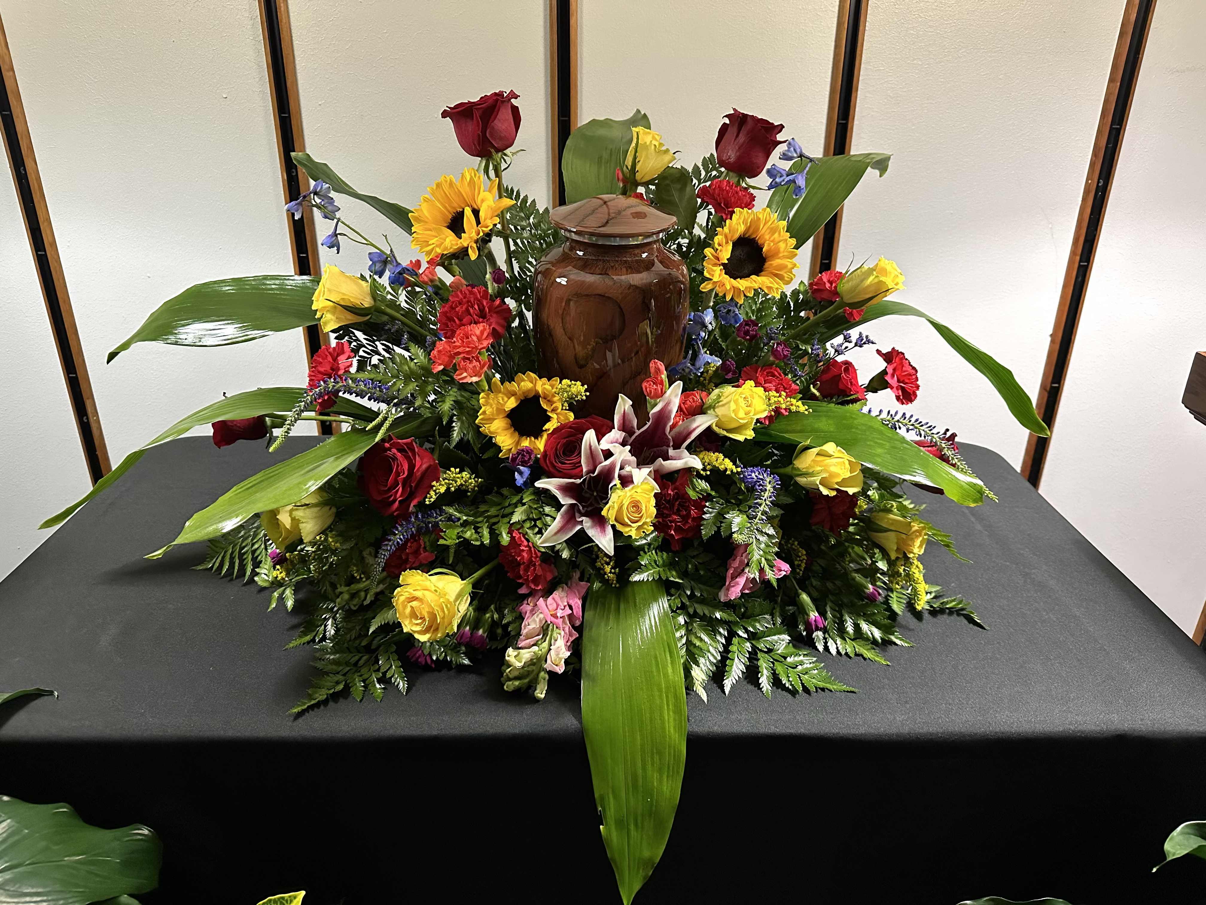 Designer's Choice Urn Spray  - Designer's Choice Urn Spray  Celebrate the life of your loved one with our Designer's Choice Urn Spray, a beautifully arranged floral tribute that reflects their spirit and memory. Our skilled florists will thoughtfully select a variety of seasonal blooms and lush greenery, creating a stunning display that complements any urn.  Each urn spray is uniquely crafted, ensuring a personalized touch that honors the individuality of your loved one. With its elegant design and vibrant colors, this arrangement serves as a heartfelt tribute, bringing comfort to those who gather to remember. Let our designers create a beautiful urn spray that speaks from the heart and adds a touch of serenity to the remembrance.