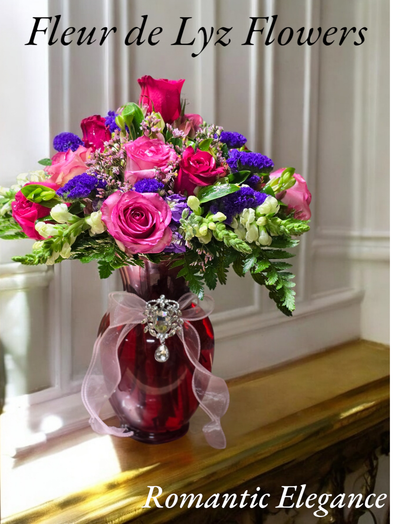 Romantic Elegance Romantic Elegance - This stunning arrangement includes Roses,Astromeria and Snap dragons This arrangement comes in a red vase and is adorned with a beautiful broche that can be later removed and worn by your special someone.