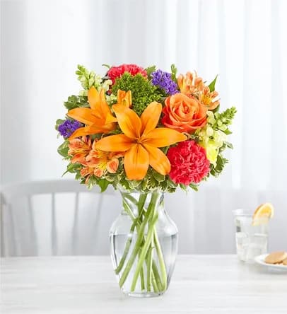 All the colors bouquet  - Putting a bright start in somebody’s day starts with a beautiful gift. Our delightfully vibrant bouquet is filled with a medley of blooms in cheerful pops of orange, pink and yellow, with plenty of lush greenery mixed in. Designed by the talented Breanna Cartwright from Fresh Ideas Flowers Company in Modesto, California, it’s the perfect pick-me-up surprise, whatever the sentiment.  All-around arrangement with orange roses, Asiatic lilies and Peruvian lilies (alstroemeria), hot pink carnations, yellow snapdragons and purple statice; accented with assorted greenery Artistically designed in a clear glass vase; measures 8&quot;H Large arrangement measures approximately 22&quot;H x 14&quot;W Medium arrangement measures approximately 21&quot;H x 13&quot;W Small arrangement measures approximately 20&quot;H x 12&quot;W Our florists select the freshest flowers available, so colors, varieties and container may vary due to local availability To ensure lasting beauty, Asiatic and Peruvian lilies may arrive in bud form and will fully bloom over the next few days