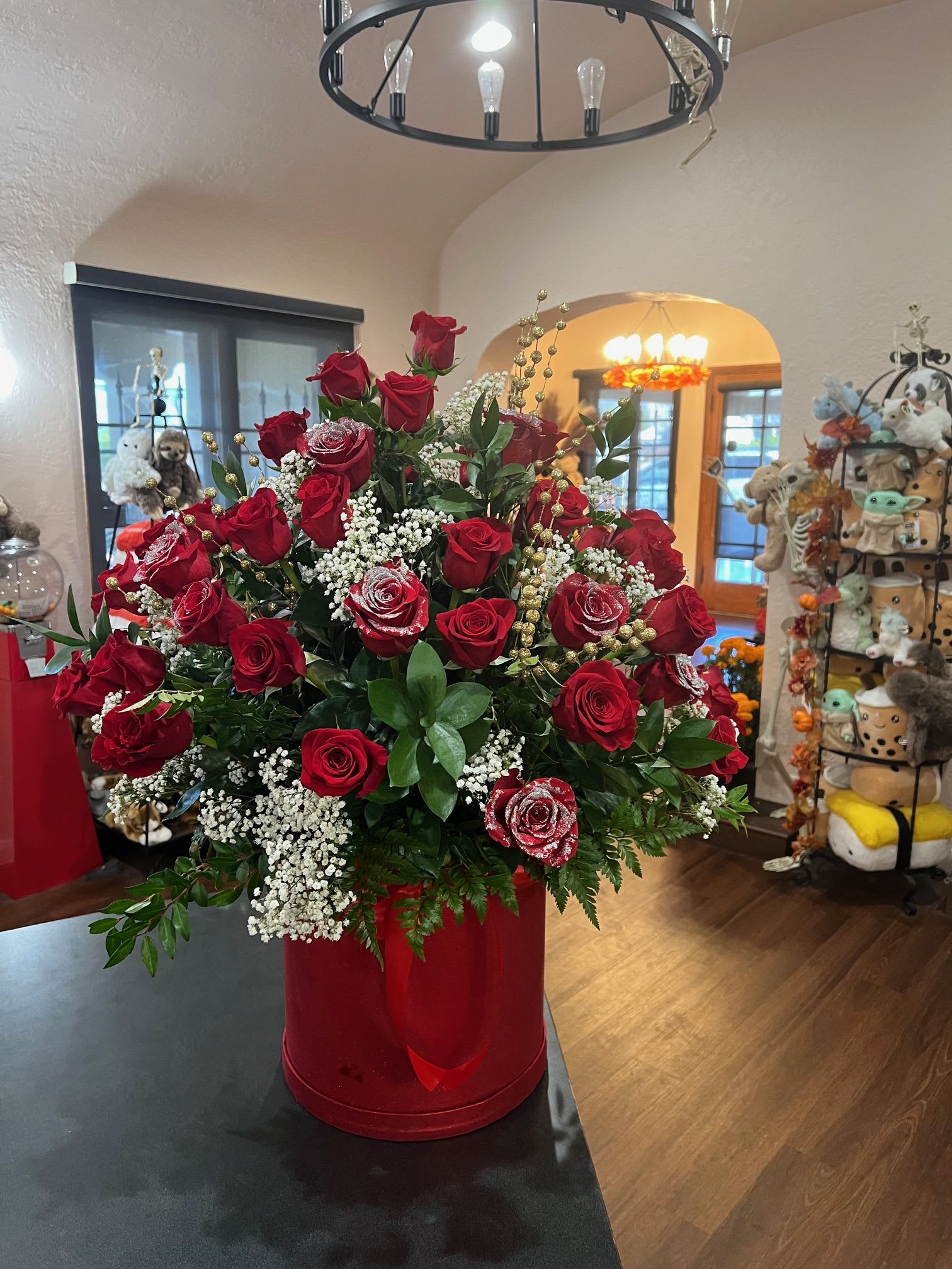 Symbol of Love - Red roses arranged inside a tall red box. glitters are added to some of the roses.