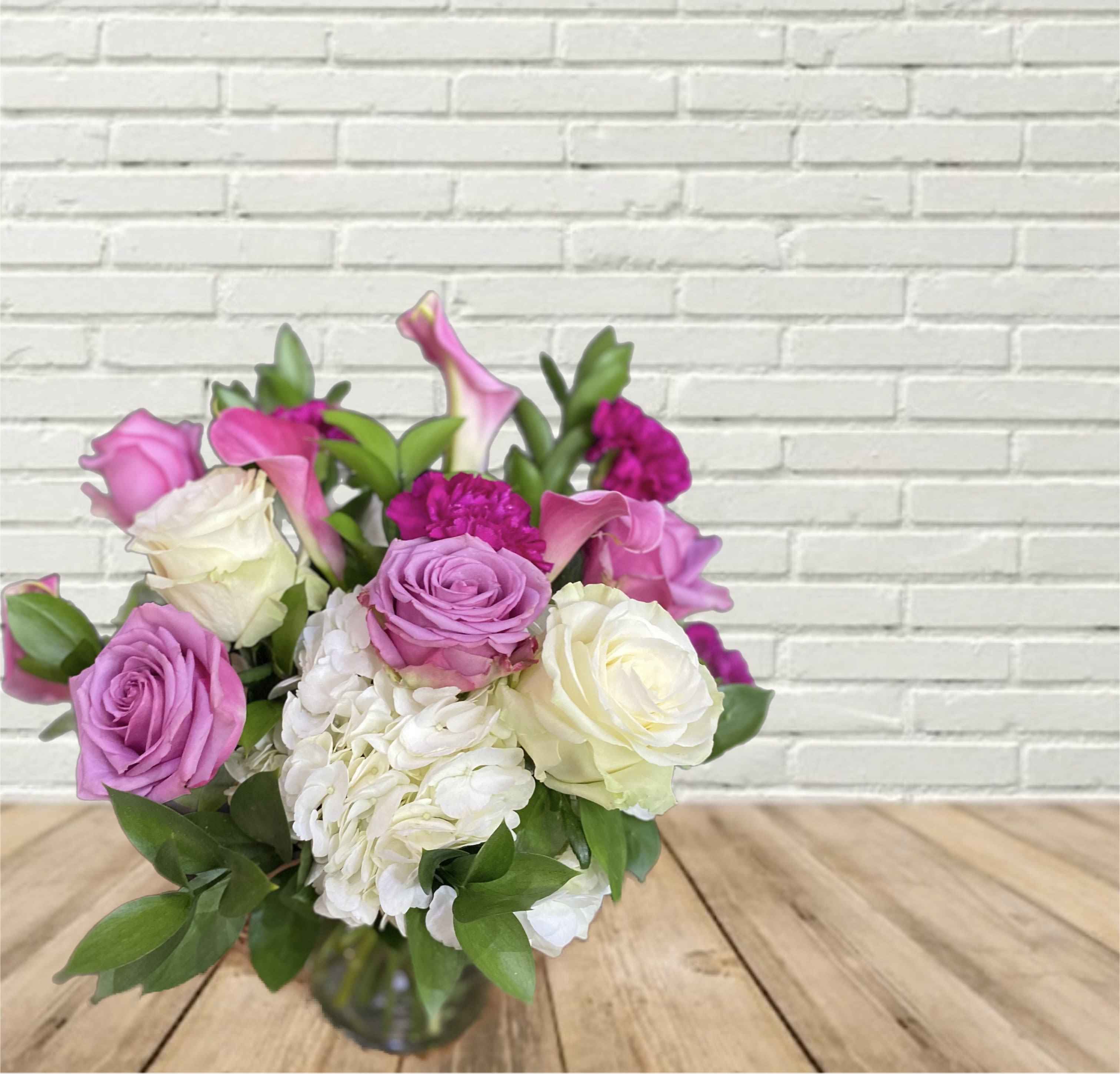 Purple Garden Purple Garden - This low & lush style beauty shows in this purple & white garden arrangement featuring hydrangeas, roses, calla lilies, & carnations.