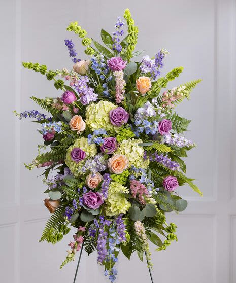 MSS#01 Sweet pastel - Carithers Pastel  Modern Stand spray  A soft, elegant floral tribute featuring garden hydrangea, snapdragons, delphinium, luxury mountain roses, and stock.