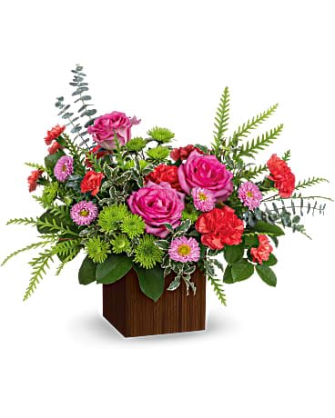 Teleflora's Catch The Sun Bouquet - Catch the sun and send it to someone special with this hot pink rose bouquet! It's arranged in a modern bamboo cube for a chic touch of Zen. Hot pink roses, orange carnations, miniature orange carnations, pink matsumoto asters and green cushion spray chrysanthemums are accented with lemon leaf, spiral eucalyptus and pitta negra. Delivered in a Large Bamboo cube.