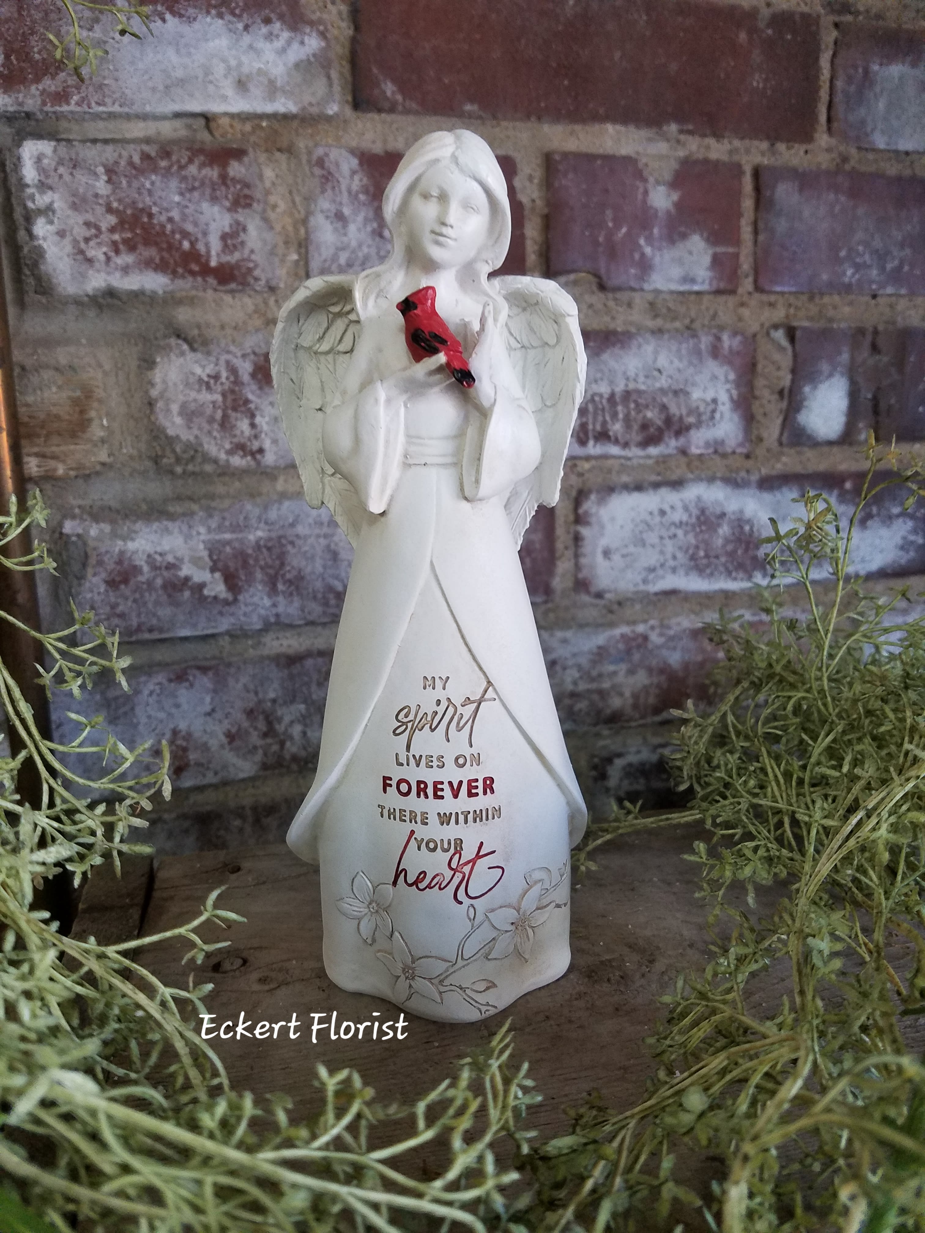 Eckert Florist's "My Spirit Lives On..." Angel *LOCAL DELIVERY ONLY Eckert Florist's "My Spirit Lives On..." Angel *LOCAL DELIVERY ONLY - Resin angel measures approx. 3" W X 8" H Sentiment: "My Spirit lives on Forever there within your heart" Can be added to a green plant or fresh arrangement. See Deluxe or Premium upgrades.