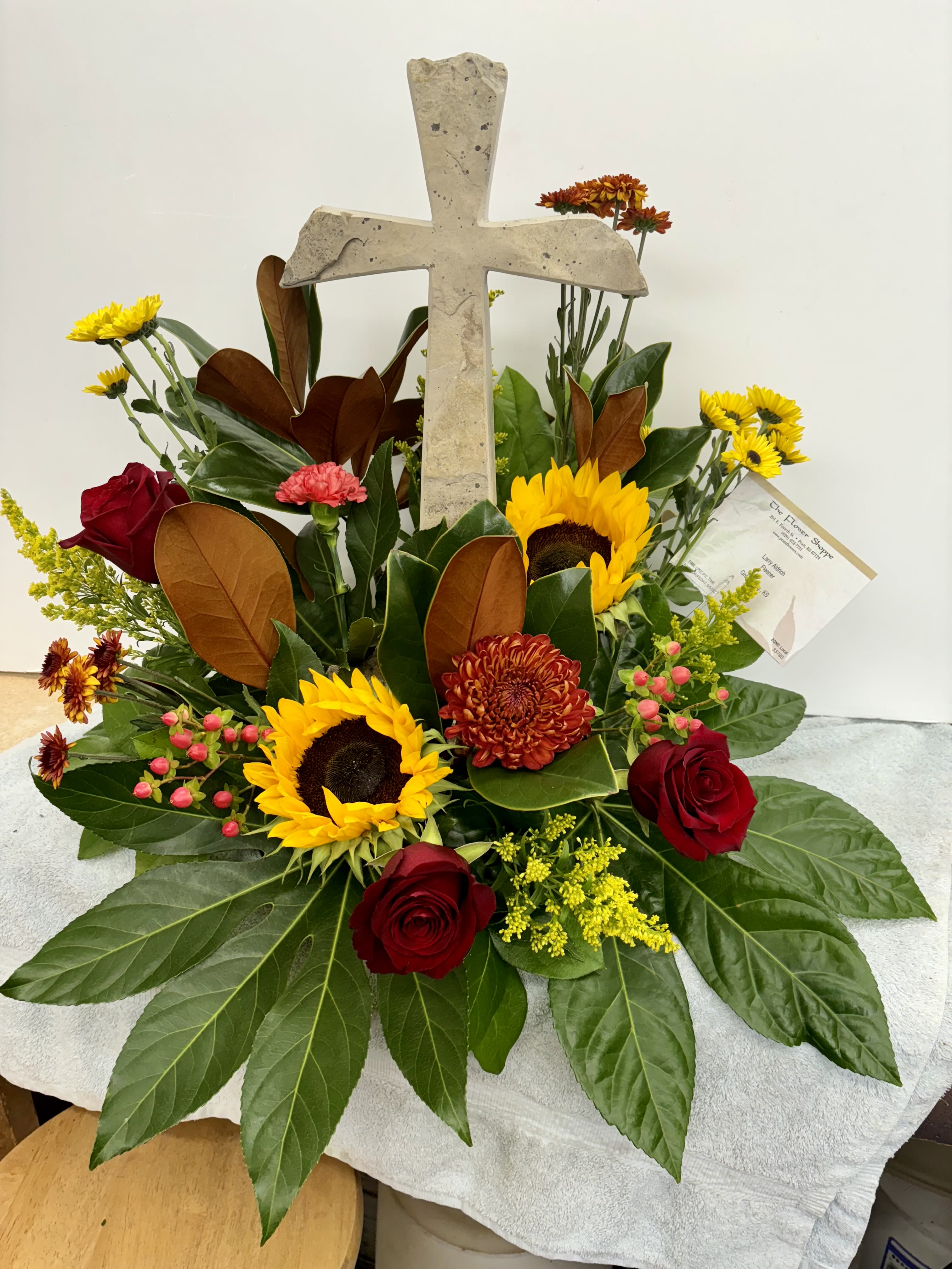 Blessed Assurance Blessed Assurance - Limestone hand-crafted cross with fresh flowers surrounding the base.