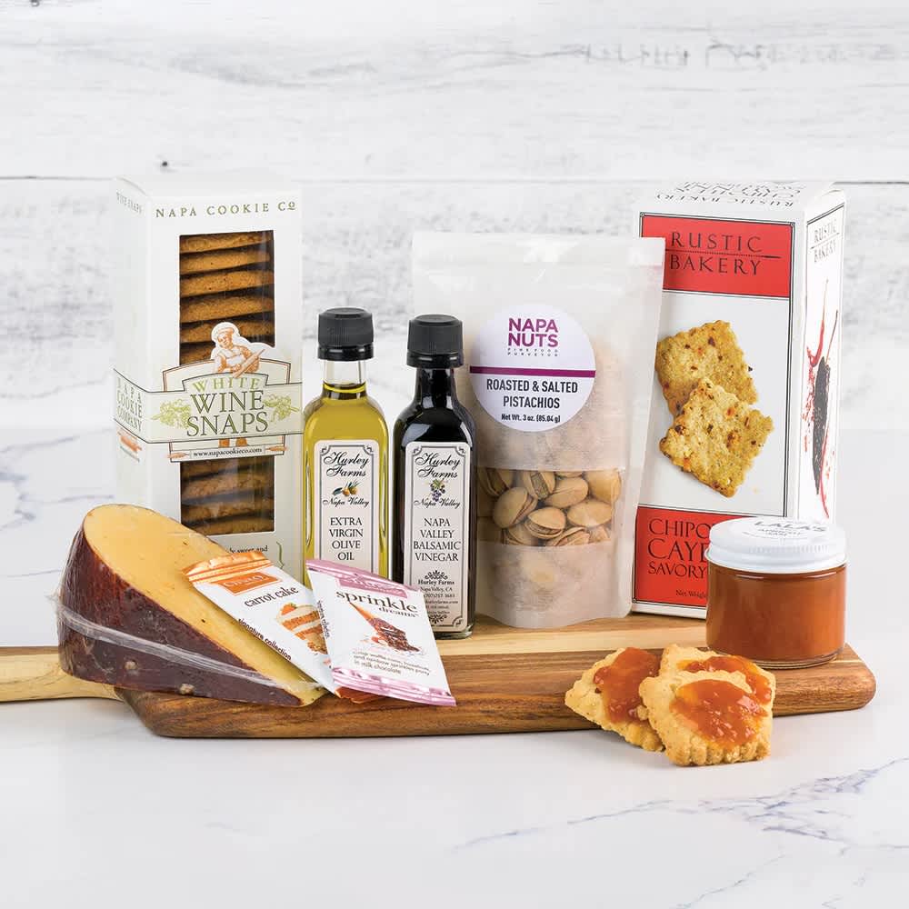 Napa Sonoma Cutting Board Essentials Gift Basket Napa Sonoma Cutting Board Essentials Gift Basket - Express some extra Gratitude for your family, friends and coworkers by sending an artisanal, locally sourced snacking experience. This Napa Sonoma Charcuterie gift has all the essentials covered including delicious cookies, Nuts, Crackers, Cheese, Chuao mini chocolate bars, Jam, and Hurley Farms Extra Virgin Olive Oil and Balsamic Vinegar. These are the perfect assortment of goodies to lay out on this beautiful wooden cutting board, and is best served when paired with your favorite Napa and Sonoma wines. Contents: Cookies, Extra Virgin Olive Oil and Balsamic Vinegar, Nuts, Crackers, Cheese*, 2 Mini Chocolate Bars, Jam and Wooden Cutting Board.