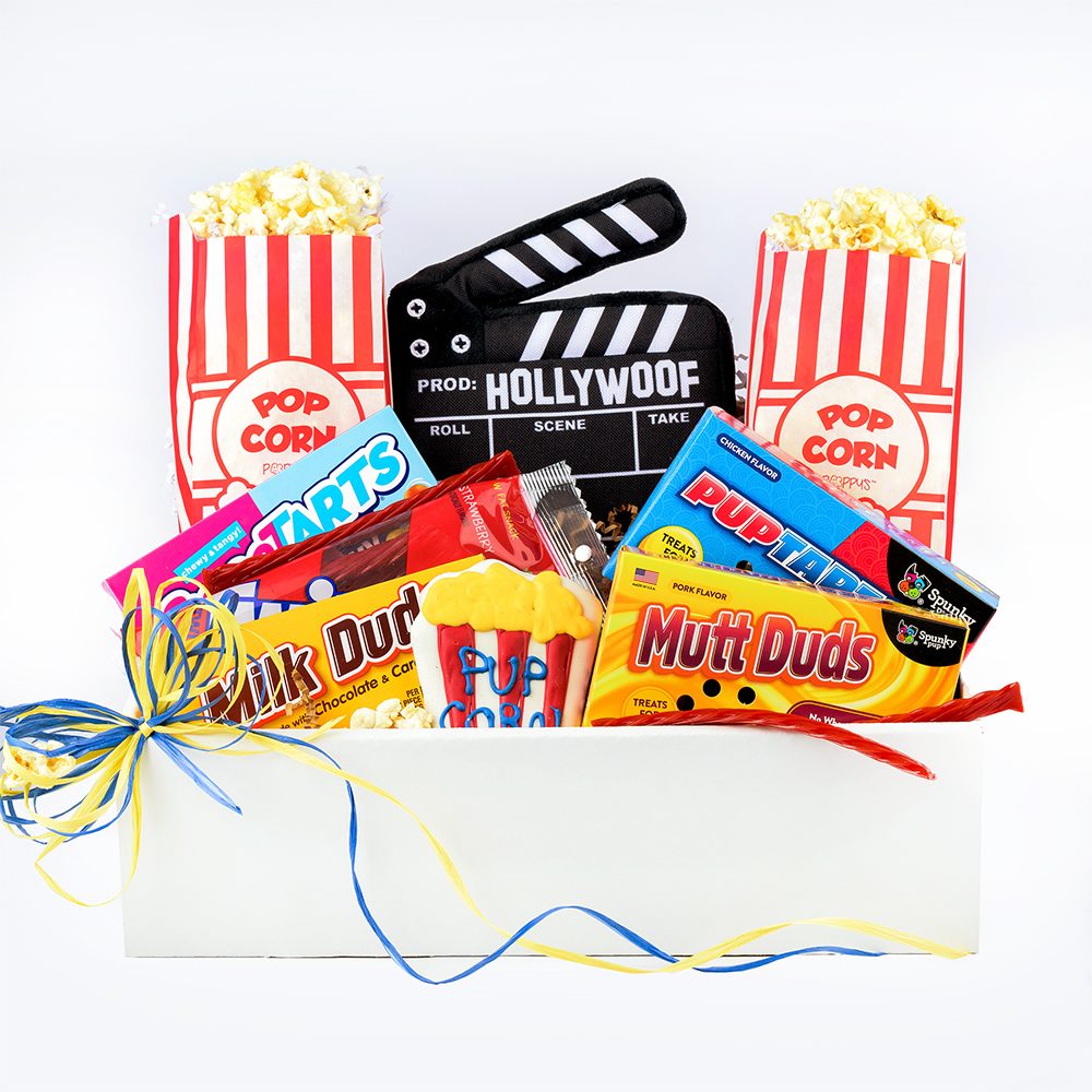 Movie Night Buddies Gift Box for Dogs and Owners Movie Night Buddies Gift Box for Dogs and Owners - Roll Out the Red Carpet for a Pawsitively Perfect Movie Night with Our Tail-Wagging Gift Box! Whether it's a cozy night in, a birthday celebration, or just because, this cinematic treat is designed to delight both the movie buff and their four-legged companion. For the humans, enjoy a delightful assortment of movie night classics – from Milk Duds and Red Vines to Sweet Tarts and popcorn with adorable popcorn bags. Meanwhile, your pup gets a starring role in the fun with Mutt-duds treats, Pup-tarts dog treats, a Hollywood-themed squeaky toy, and a paw-licking good Pup-corn baked and decorated dog treat. It's a blockbuster celebration for both the film enthusiast and their canine co-star! As you dim the lights and press play, here's to the joy of shared moments, laughter, and the simple pleasures that make movie nights memorable. Lights, camera, action! Includes: Human: 1 bag of Microwavable Popcorn, 2 Paper Popcorn Bags, Sweet Tarts, Red Vines, Milk Duds Dog: Hollywoof Plush Toy, PupTarts Dog Candy, Mutt Duds Dog Candy, Pup-Corn Baked Treat