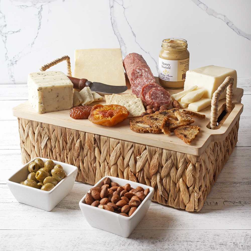 Charcuterie Basket and Cutting Board Duo Charcuterie Basket and Cutting Board Duo - A gourmet collection that transforms any gathering into an elegant affair. This curated basket features a delightful assortment of cheeses, perfectly paired with crisp artisan crackers and salami for a savory delight. Enhance your palate with the tangy touch of honey mustard and the satisfying crunch of almonds. Complement these flavors with briny olives and artisan crisps for an authentic charcuterie experience. Accompanied by a stylish cutting board, this duo offers both practicality and indulgence, making it an ideal gift for any occasion. Enjoy the art of charcuterie with this exquisite ensemble. Contents: Cheese, crackers, salami, honey mustard, artisan crisps, cheese, cheese, olives, almonds, basket container lid is a cutting board!