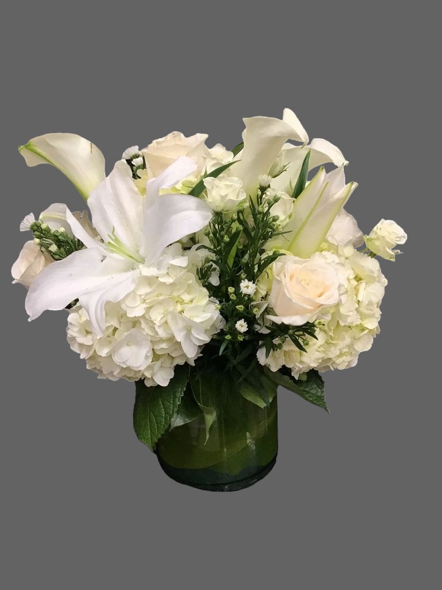 ALL WHITE LOW CENTERPIECE ALL WHITE LOW CENTERPIECE - This is a nice all white centerpiece for any occasion. Mix of white casablanca lillies, white monte casino fillers, white hydrangeas, white roses and wite calla lillies.