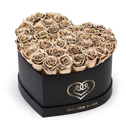Metallic Gold Roses | Black "Love" Logo Box Metallic Gold Roses | Black "Love" Logo Box - The "heart box collection" consists of unique, real preserved roses handcrafted, soft, and elegant heart box with a top. Luxury arrangement of about 25-31 stems of the one long lasting (med size) real preserved roses.  Durability: approx. 1-3 years.  Our roses, which are carefully sourced from the highest quality gardens in Ecuador, are made to represent the eternal yet ephemeral nature of Love itself. Our Roses are specially customized with essential oils to increase the fragrance.  Product Care: DO NOT Water the roses! AVOID direct exposure to sunlight. Keep the arrangement in a room-temperature environment. If dust collects after a few months, remove it lightly using a duster. DO NOT place anything onto the roses as they can crush and damage the roses. DO NOT remove the roses from the box; they are secure and happy there. DO NOT allow roses to have direct contact with light colored fabric or surfaces, as staining may occur. The lid is meant to stay on the side or bottom of the box. Be mindful when carrying the arrangement: it's a very delicate product!