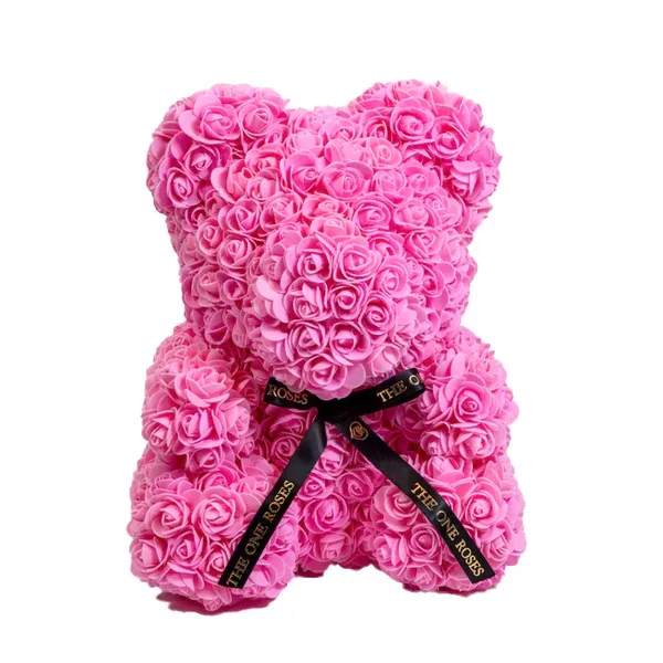 Pink Rose Bear Pink Rose Bear - Give someone special our gorgeous The One Rose Bear handmade of roses that last forever.  The perfect gift that will look great as a decoration piece in your loved one's home or office. Designed with synthetic roses in beautiful colors, this handmade Rose Bear lasts a lifetime with no care needed!  The best gift for Birthdays, Christmas, Valentine's Day, Mother's Day, Anniversaries, Baby Showers, Gender Reveal, Proposals, Weddings, or any occasion that warrants such a unique and precious gift.  Our authentic Rose Bear comes with our The One Roses Satin Bow and is available only in medium (14 inch) size.  What's Included?  The One Roses Signature Gift Box The One Roses Satin Ribbon The One Roses Rose Bear of your choice of color
