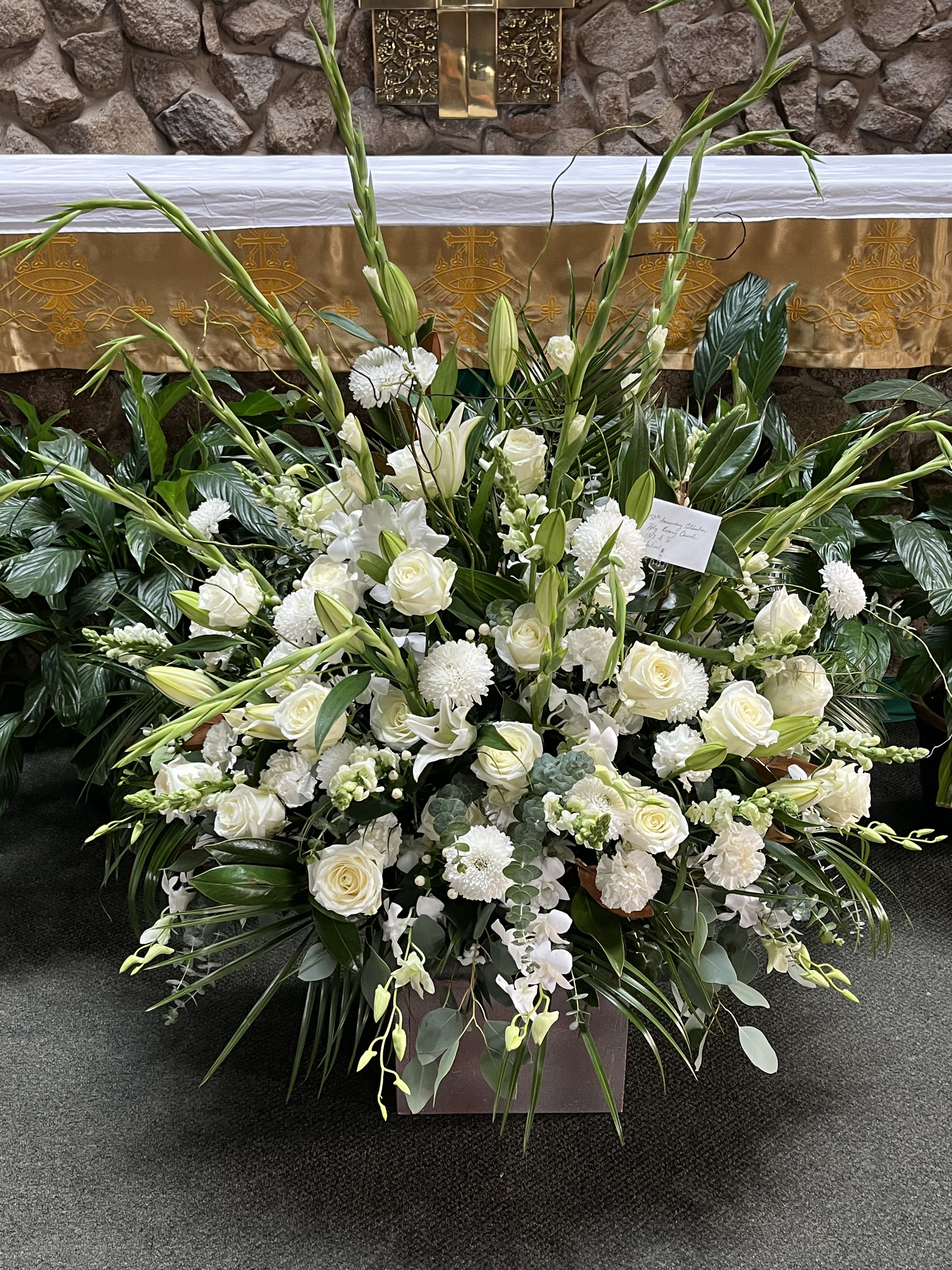 Ultra Large Altar Arrangement Ultra Large Altar Arrangement - Very large container of all white flowers arranged to be viewed from three sides. Perfect for in front of an altar for a church service. Approximately 4ft tall and 4-5ft wide.