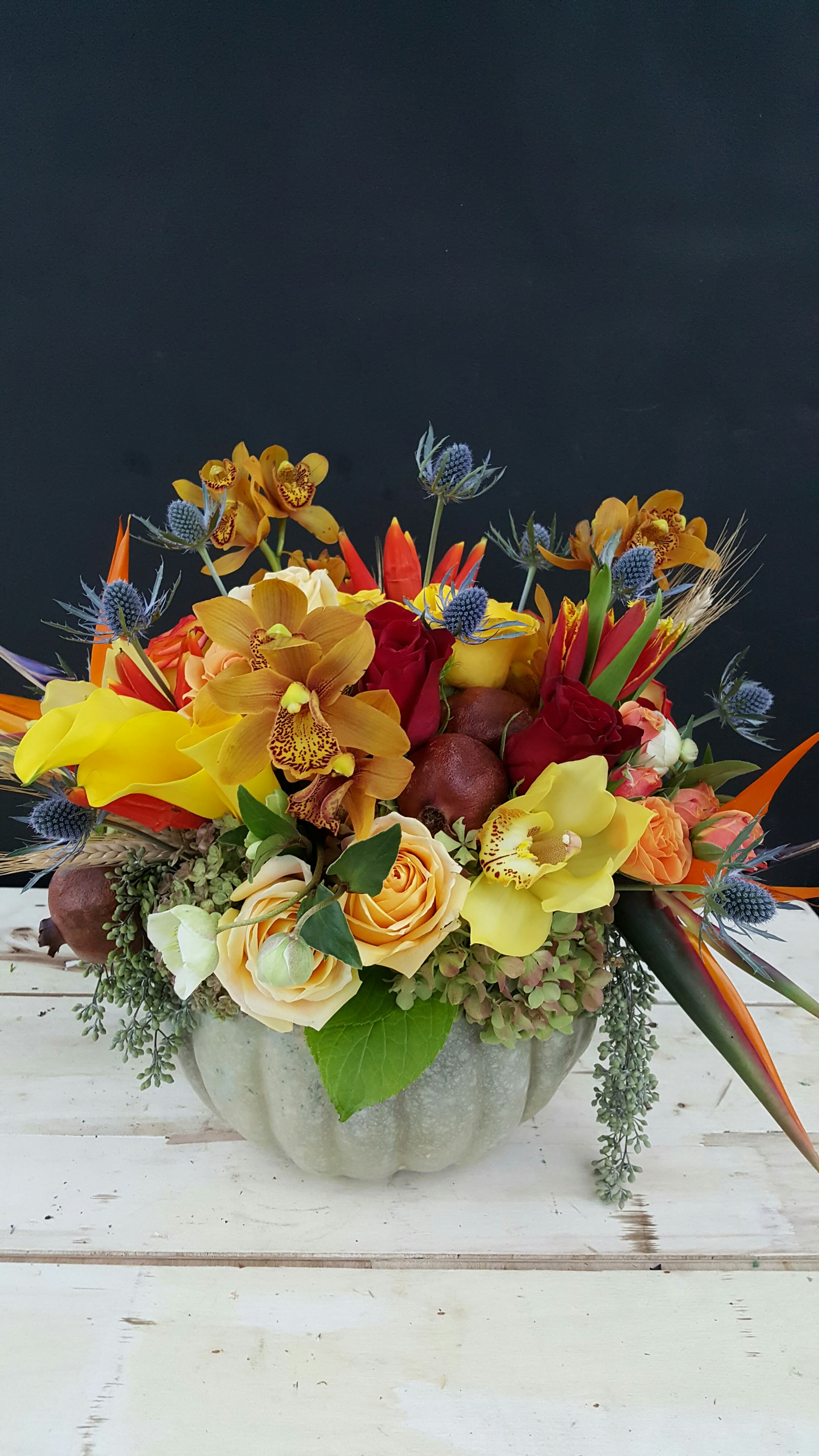 Graceful Elegance: Flowers Artfully Arranged in a Grey Pumpkin Graceful Elegance: Flowers Artfully Arranged in a Grey Pumpkin - "Graceful Elegance" is a sophisticated and artistically arranged floral masterpiece where nature's beauty meets the chic allure of a grey pumpkin. This unique arrangement transforms the pumpkin into a canvas, showcasing an array of flowers in a tasteful burst of colors. With each bloom carefully selected and placed, this arrangement captures the essence of refined autumn artistry. Join us as we explore this enchanting display, where flowers and the muted elegance of a grey pumpkin unite to create a harmonious blend of nature's beauty and the stylish spirit of the season. Varieties and colors of flowers may vary according to season and availability. This arrangement includes a newly cleaned vase and good quality water & flower food. Care Instructions: For the best vase life, change the water every two days. Item: 1718