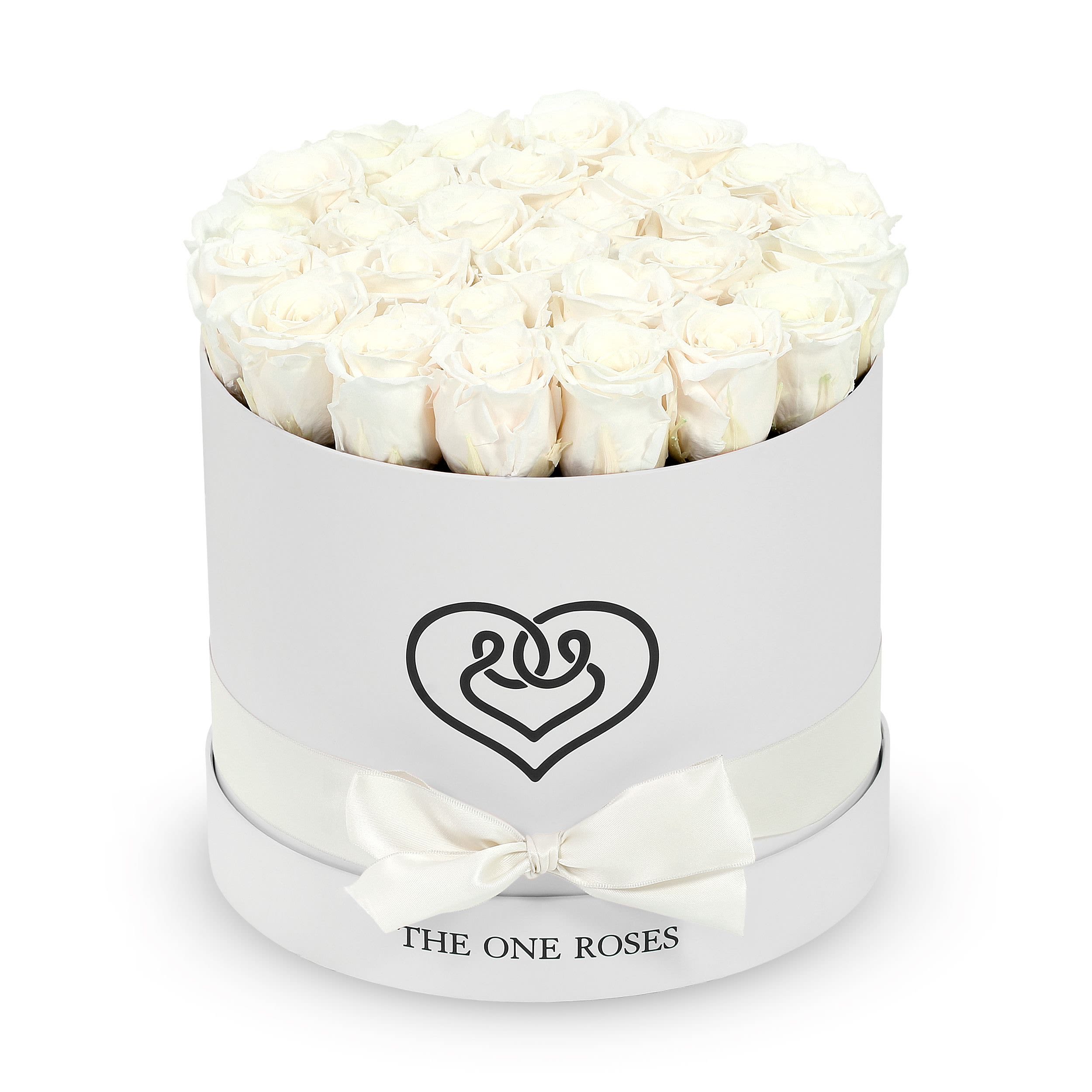Round Flat | Classic White Box Pearl White Round Flat | Classic White Box Pearl White - The "runway round collection" consists of unique, real preserved roses in classic round handcrafted luxury soft touch box with a top. About 25-30 stems of the one long lasting (med size) preserved roses.  Durability: approx. 1-3 years.  Our roses, which are carefully sourced from the highest quality gardens in Ecuador, are made to represent the eternal yet ephemeral nature of Love itself. Our Roses are specially customized with essential oils to increase the fragrance.  Product Care: DO NOT Water the roses! AVOID direct exposure to sunlight. Keep the arrangement in a room-temperature environment. If dust collects after a few months, remove it lightly using a duster. DO NOT place anything onto the roses as they can crush and damage the roses. DO NOT remove the roses from the box; they are secure and happy there. DO NOT allow roses to have direct contact with light colored fabric or surfaces, as staining may occur. The lid is meant to stay on the side or bottom of the box. Be mindful when carrying the arrangement: it's a very delicate product!