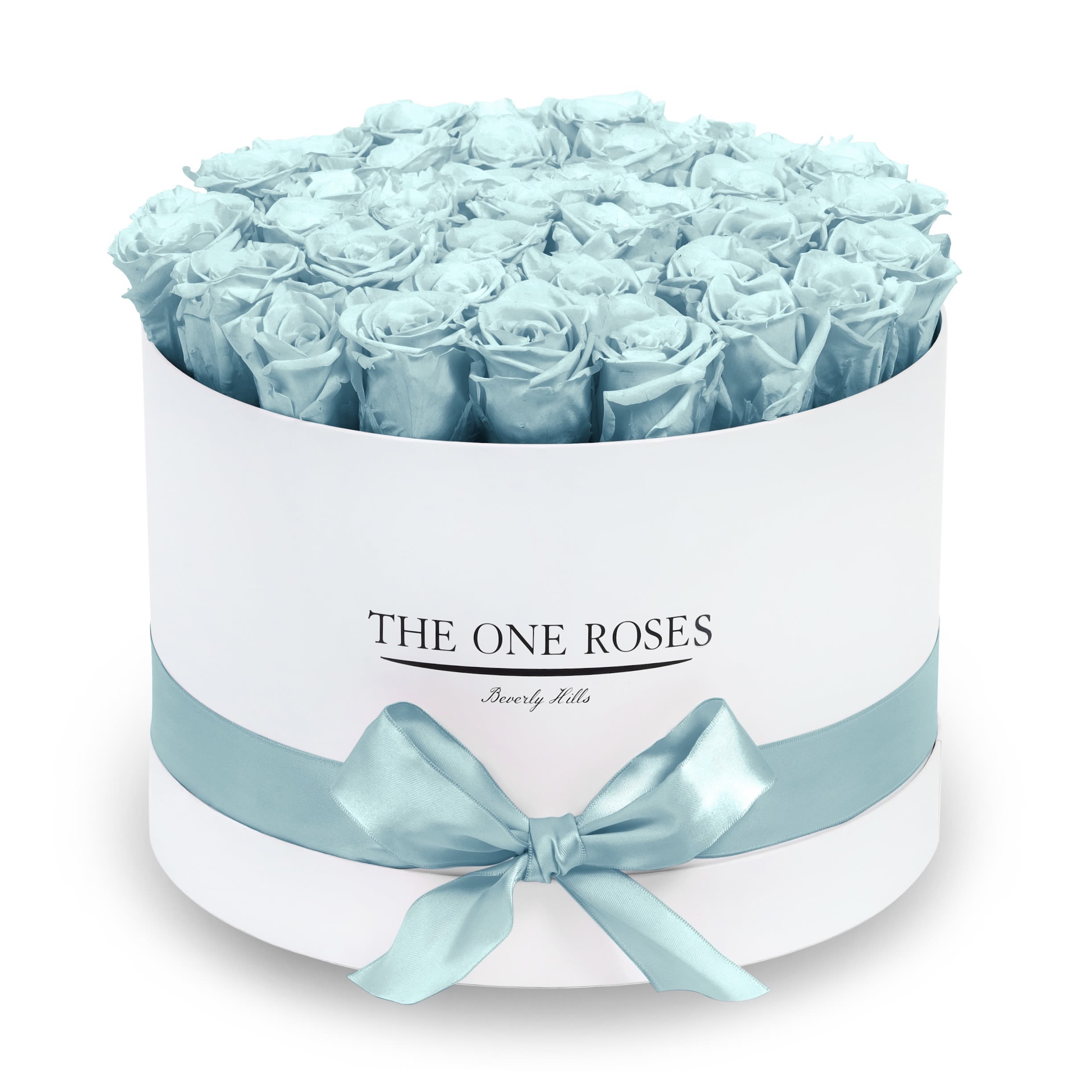 Round Flat | Premium White Box Frozen Blue Round Flat | Premium White Box Frozen Blue - The “Runway Round Collection”. consists of unique, real preserved roses in premium round handcrafted luxury soft touch box with a top. About 30-36 stems of The One long lasting (med size) preserved roses.  Durability: approx. 1-3 years.  Our roses, which are carefully sourced from the highest quality gardens in Ecuador, are made to represent the eternal yet ephemeral nature of Love itself. Our Roses are specially customized with essential oils to increase the fragrance.  Product Care: DO NOT Water the roses! AVOID direct exposure to sunlight. Keep the arrangement in a room-temperature environment. If dust collects after a few months, remove it lightly using a duster. DO NOT place anything onto the roses as they can crush and damage the roses. DO NOT remove the roses from the box; they are secure and happy there. DO NOT allow roses to have direct contact with light colored fabric or surfaces, as staining may occur. The lid is meant to stay on the side or bottom of the box. Be mindful when carrying the arrangement: it's a very delicate product!
