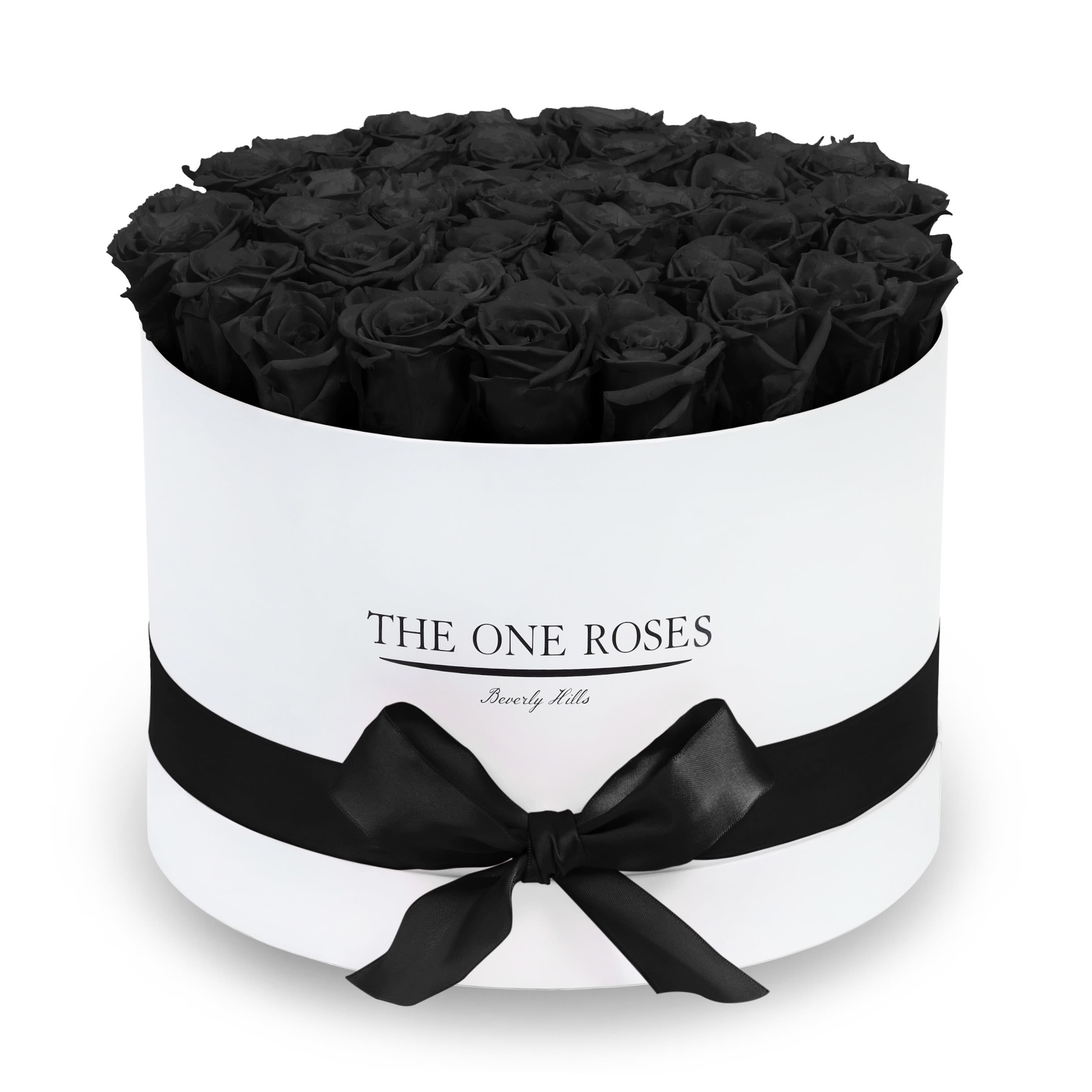 Round Flat | Premium White Box Onyx Black Round Flat | Premium White Box Onyx Black - The “Runway Round Collection”. consists of unique, real preserved roses in premium round handcrafted luxury soft touch box with a top. About 30-36 stems of The One long lasting (med size) preserved roses.  Durability: approx. 1-3 years.  Our roses, which are carefully sourced from the highest quality gardens in Ecuador, are made to represent the eternal yet ephemeral nature of Love itself. Our Roses are specially customized with essential oils to increase the fragrance.  Product Care: DO NOT Water the roses! AVOID direct exposure to sunlight. Keep the arrangement in a room-temperature environment. If dust collects after a few months, remove it lightly using a duster. DO NOT place anything onto the roses as they can crush and damage the roses. DO NOT remove the roses from the box; they are secure and happy there. DO NOT allow roses to have direct contact with light colored fabric or surfaces, as staining may occur. The lid is meant to stay on the side or bottom of the box. Be mindful when carrying the arrangement: it's a very delicate product!